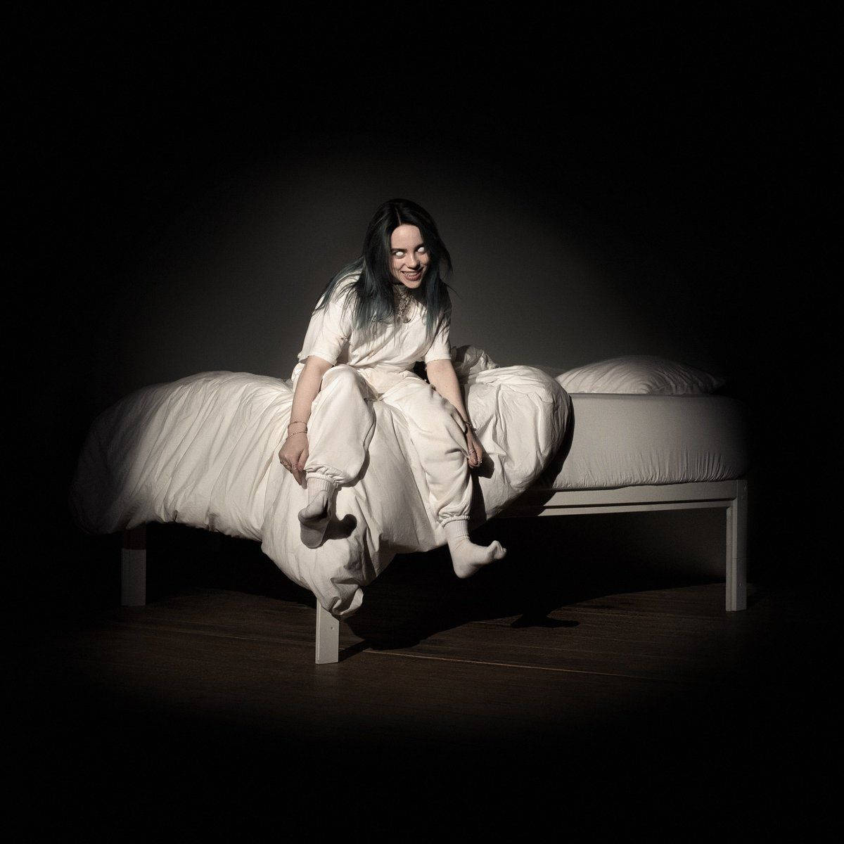 Billie Eilish《When We All Fall Asleep, Where Do We Go?》專輯封面床坐姿美學照 壁紙 — 一位身穿白衣的女性在黑色背景的戲劇性聚光燈下躺臥在床上。