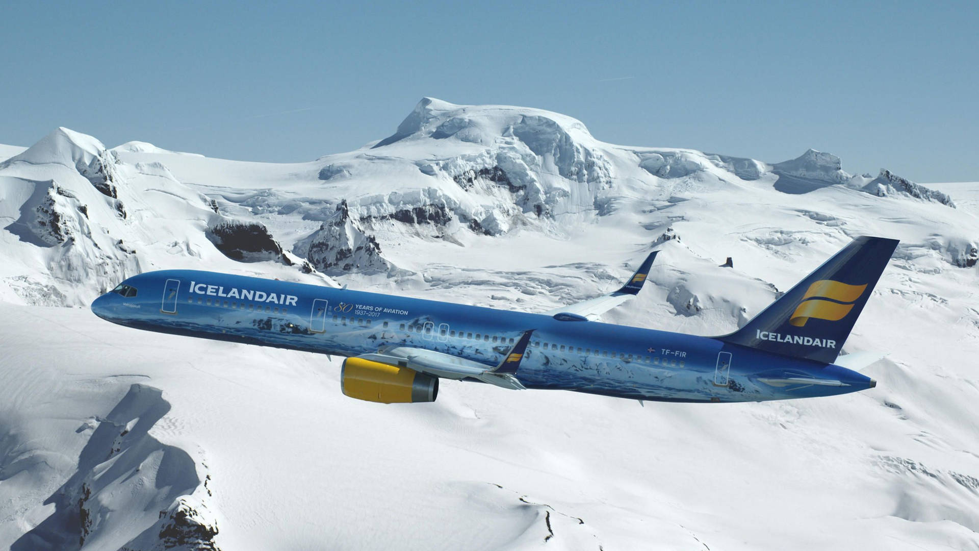 藍黃相間的冰島航空飛機飛越積雪山脈。