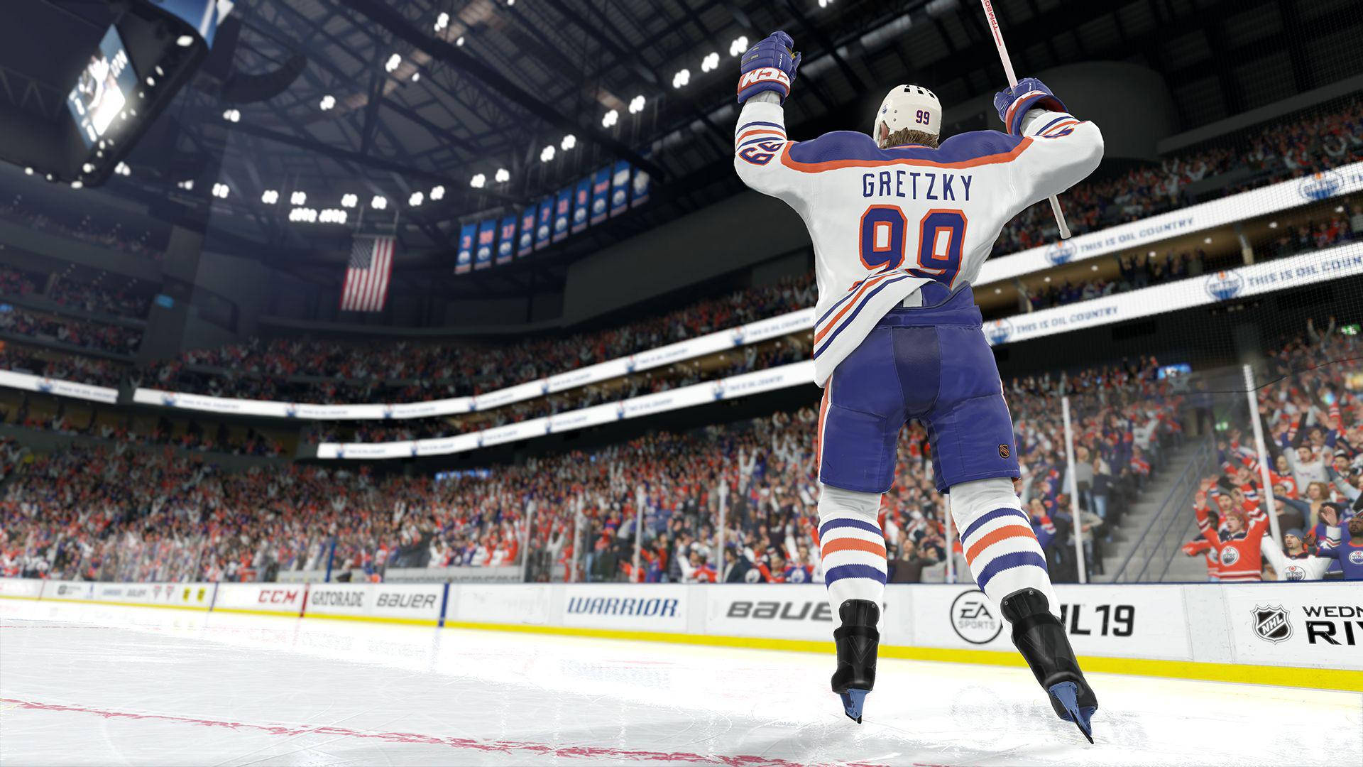 精彩NHL 19官方遊戲截圖 壁紙 — 冰球傳奇人物格雷茨基在明亮的體育場燈光下，在冰上勝利躍起，全場球迷歡呼沸騰。