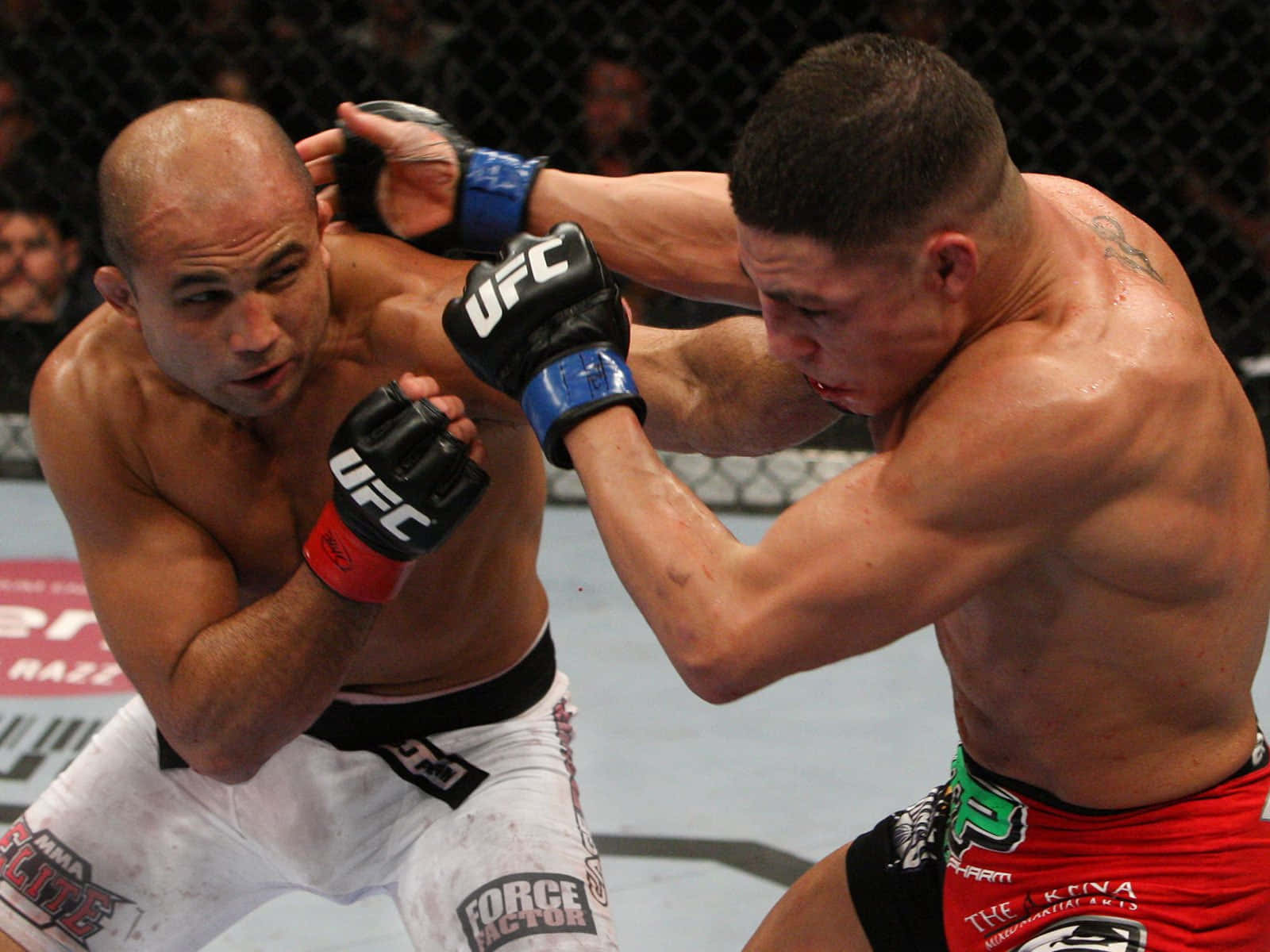 BJ Penn對決Diego Sanchez於UFC 107（2009） 壁紙 — 兩名肌肉發達的MMA拳手在激烈的鐵籠賽中對戰，汗水飛濺，手套交纏。