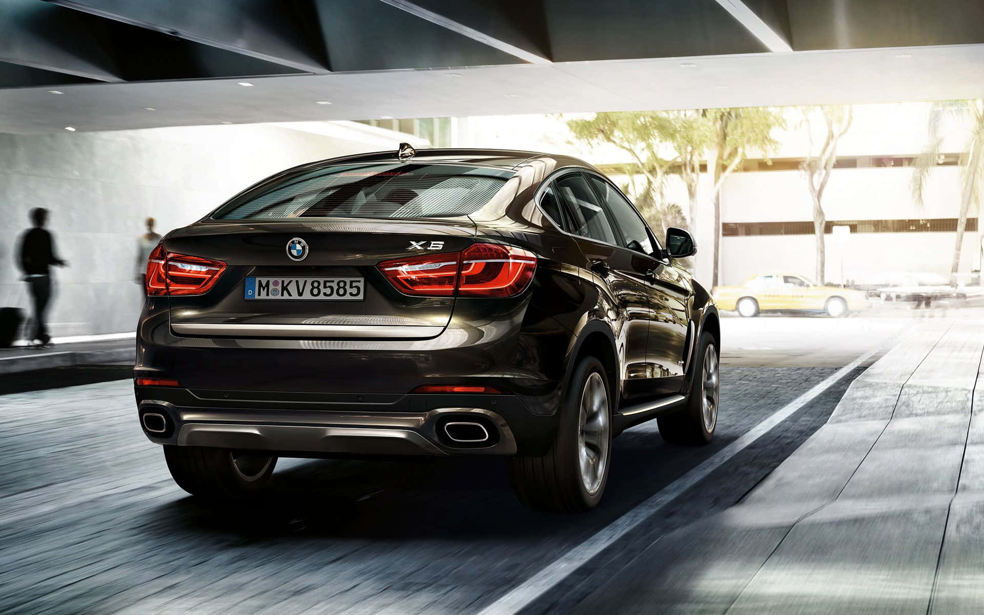 Bmw X6 桌布 壁紙 — 一輛時尚的黑色BMW X6 SUV在現代城市隧道中行駛，帶有動態模糊和明亮的陽光射入。