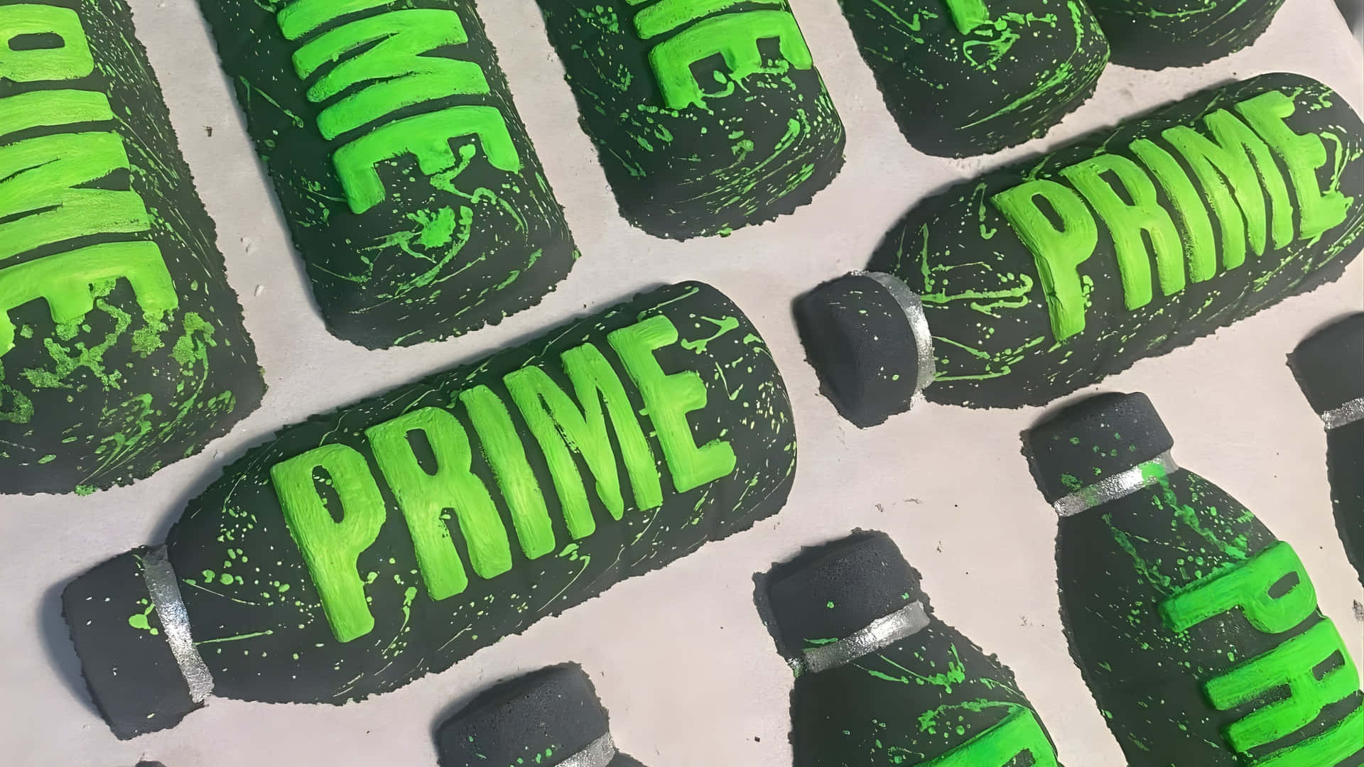  壁紙 — 黑色瓶形蛋糕，帶有亮綠色「PRIME」文字和飛濺細節，排列在淺色表面上。
