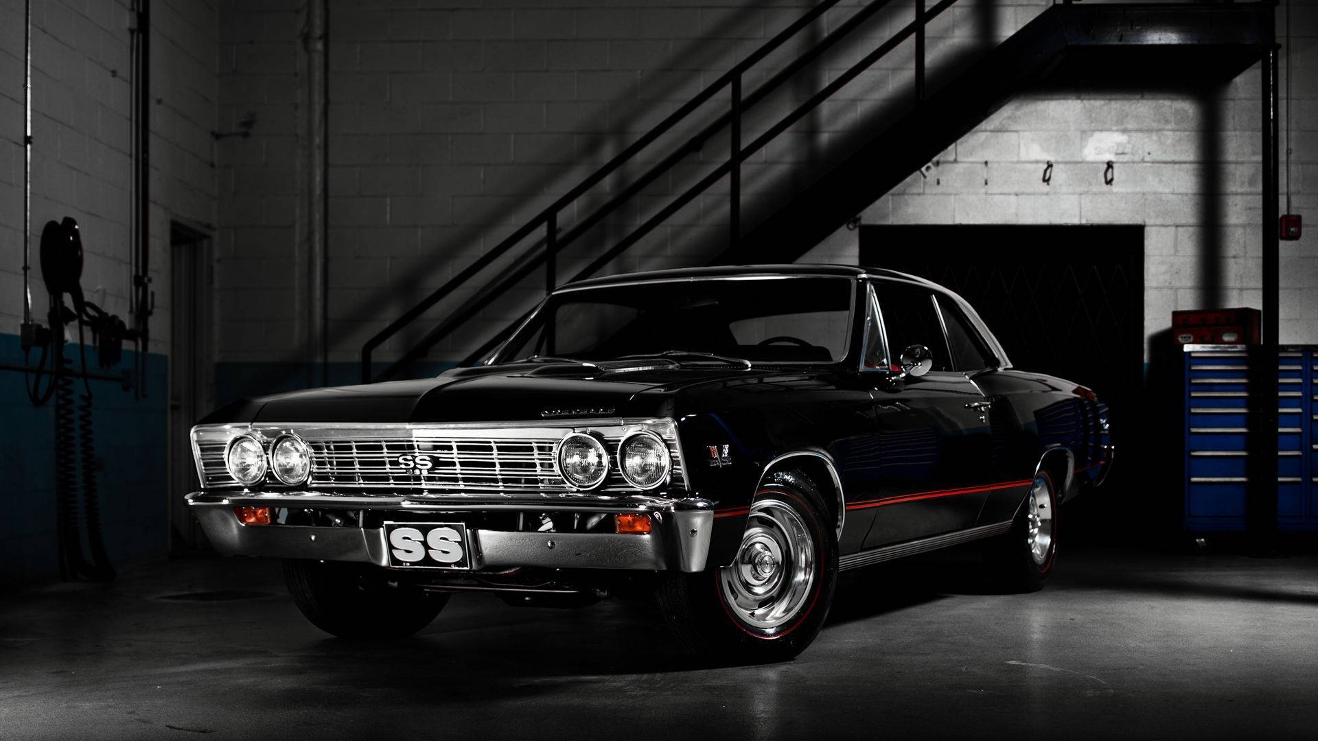 Black Chevrolet Chevelle Classic Car 壁紙 — 一架時尚的黑色經典雪佛蘭SS肌肉車在粗獷的工業車庫中，在戲劇性的燈光下閃閃發光。