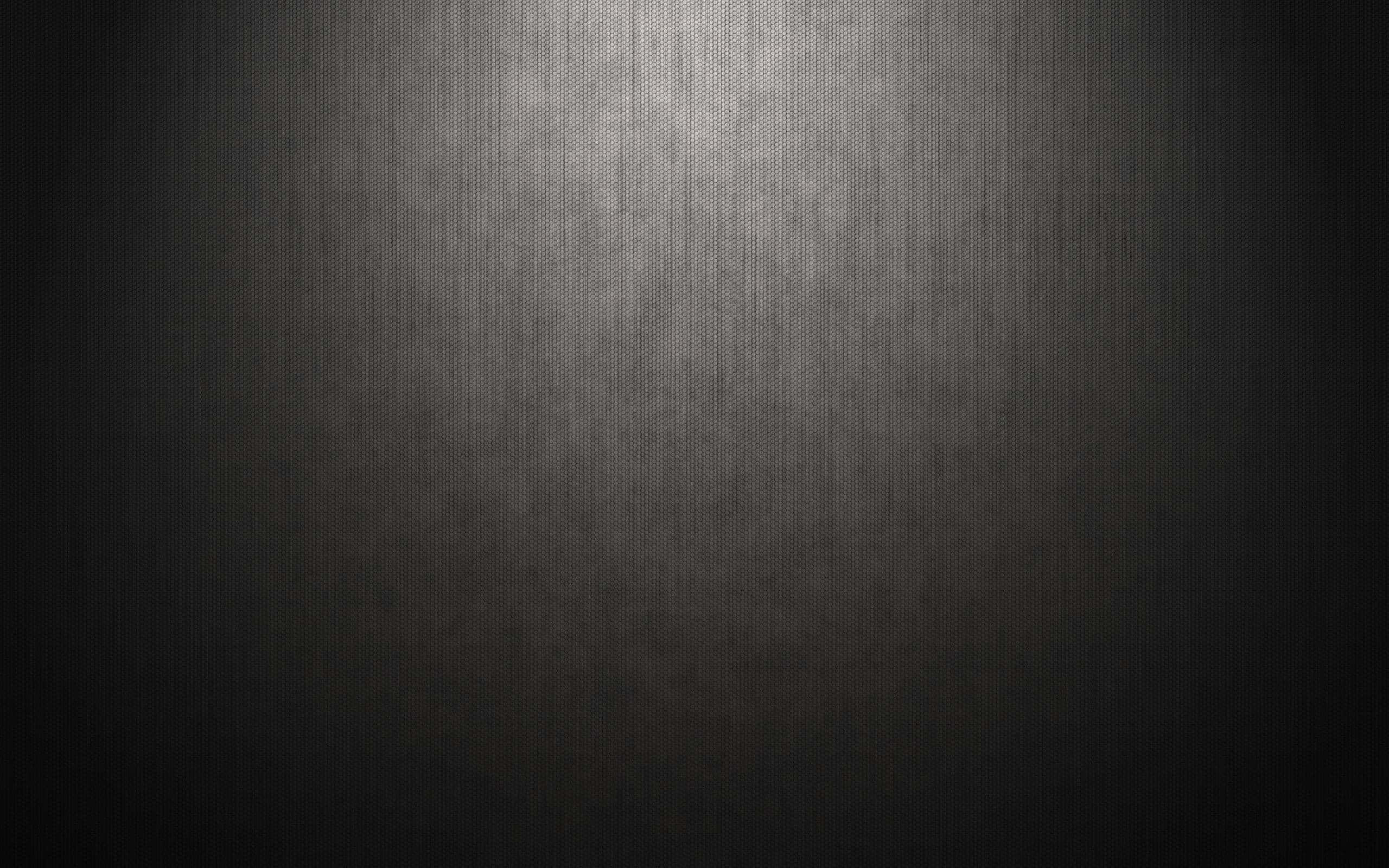  壁紙 — 深色紋理表面，帶有從中心向邊緣漸變的柔和聚光燈效果。