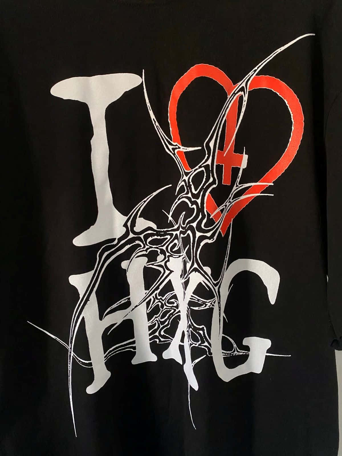  壁紙 — 黑色T恤，粗體白色「I」和「HXC」在兩側，中間是一個被白色華麗匕首刺穿的紅色心形。