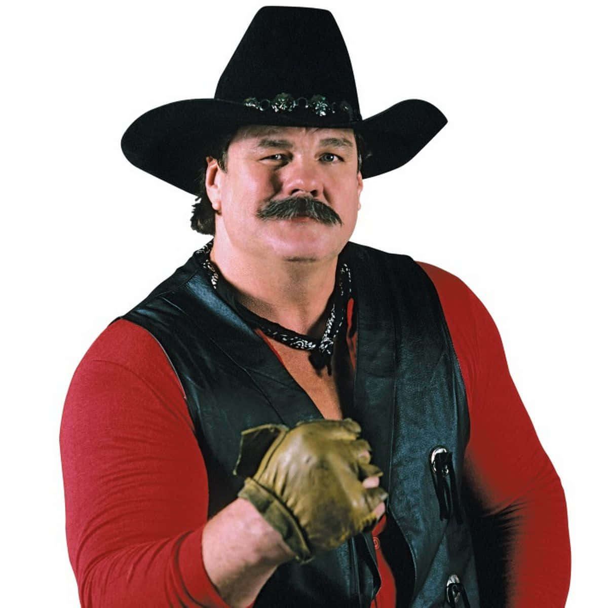 職業摔角手Blackjack Mulligan 壁紙 — 一個肌肉發達、留著濃密鬍子的男人，戴著黑色牛仔帽、紅色襯衫和黑色背心，戴著皮手套向前指。