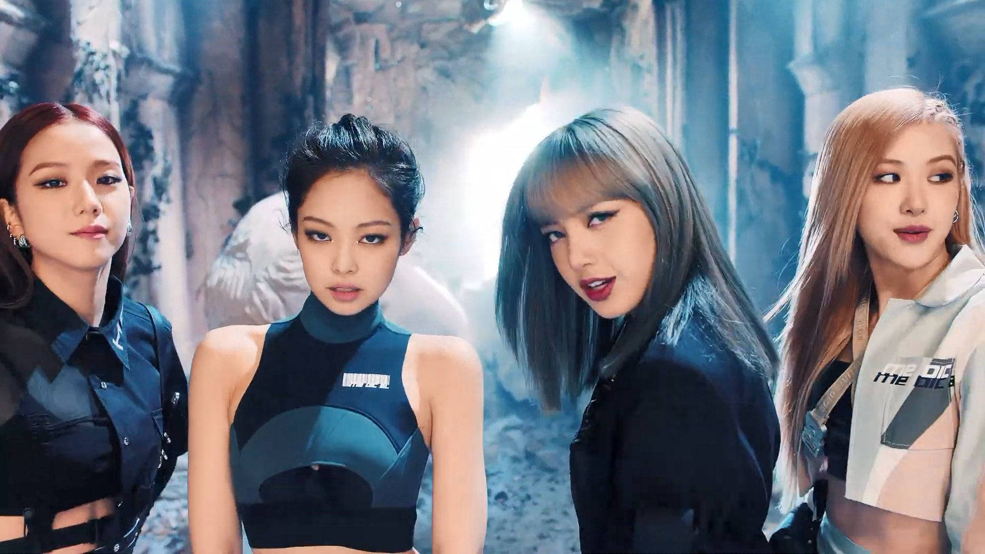 金珍妮與BLACKPINK成員強勢表情 壁紙 — 四位時尚女性在燈光昏暗、破敗的城市環境中自信地擺姿勢，光線充滿戲劇性。