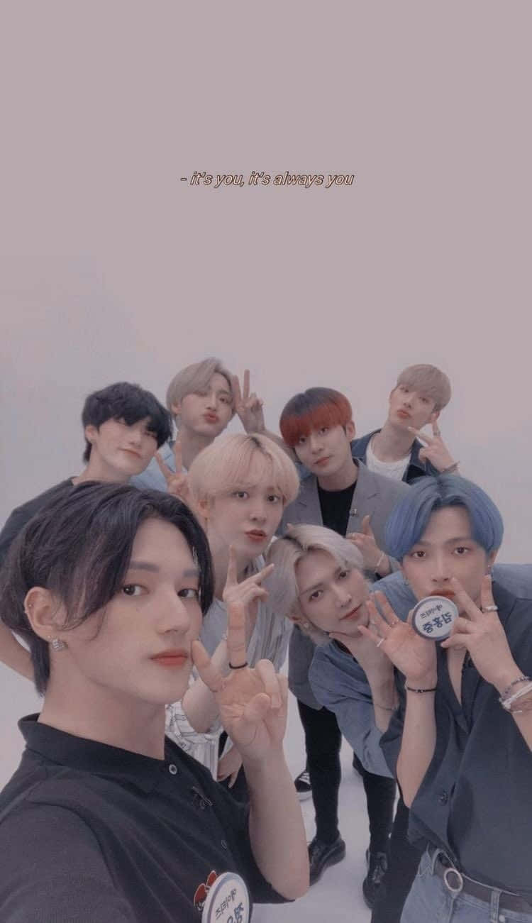 Blackpink Jisoo的迷人姿態 壁紙 — 七位年輕男子擁有色彩繽紛的頭髮，在柔和的粉紅色背景前緊密地擺出和平手勢。