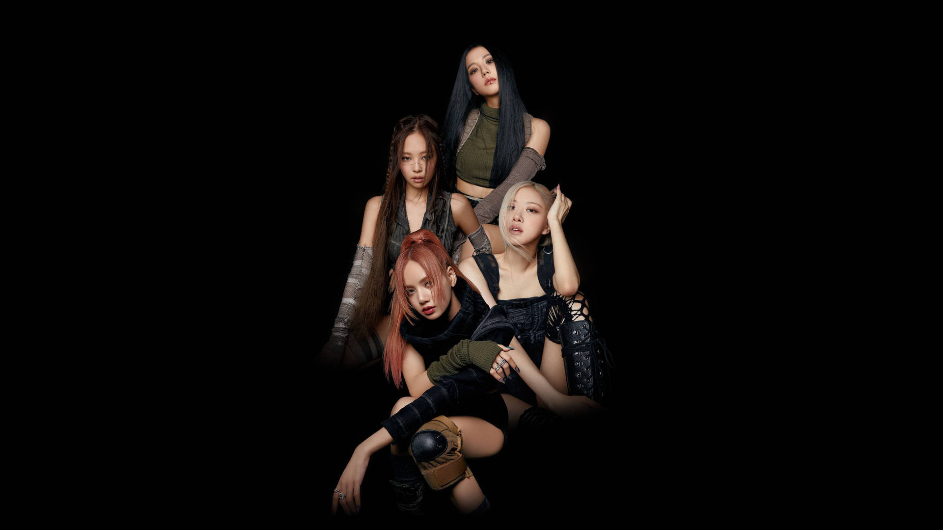BLACKPINK《Pink Venom》概念預告照 壁紙 — 四位時尚女性穿著前衛服裝，在強烈燈光下，於純黑背景前戲劇性地擺姿勢。