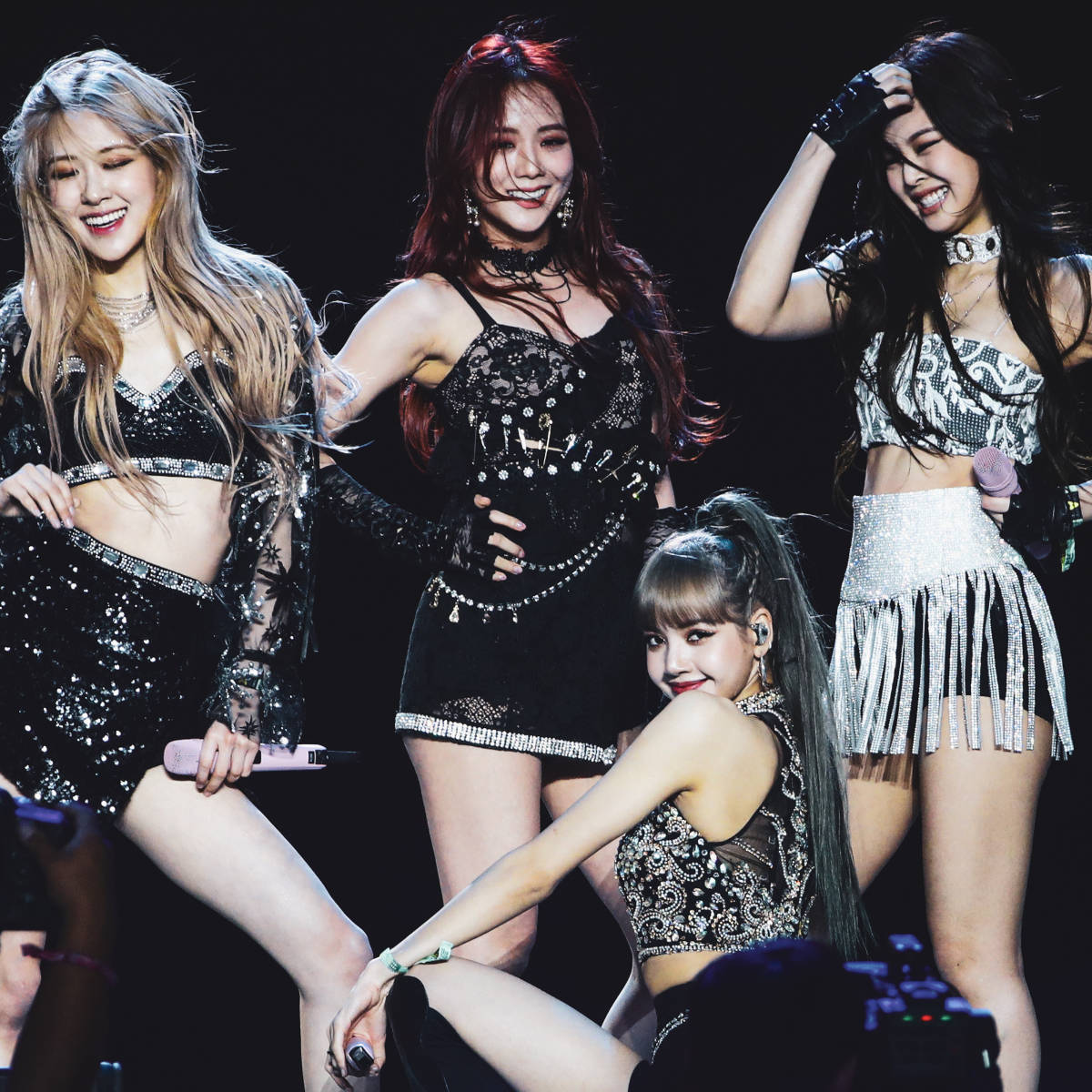 BLACKPINK Sheesh舞台表演後合影 壁紙 — 四位女K-pop偶像身穿閃亮黑色和銀色服裝，在明亮的舞台燈光下擺出動感姿勢。