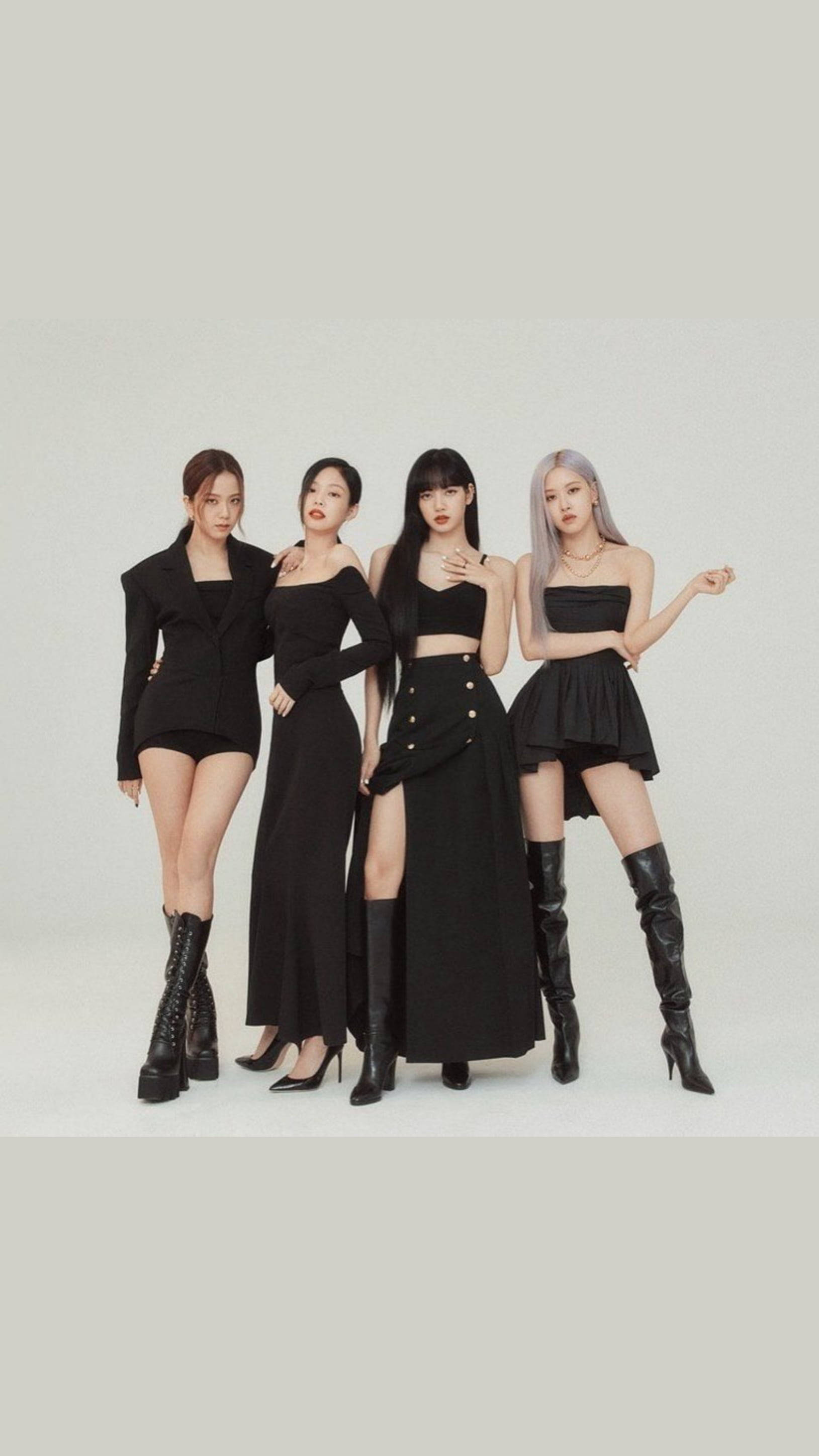 BLACKPINK《The Album》智秀 壁紙 — 四位時尚女性身穿別緻的黑色服裝，在純淺灰色攝影棚背景前自信地擺姿勢。