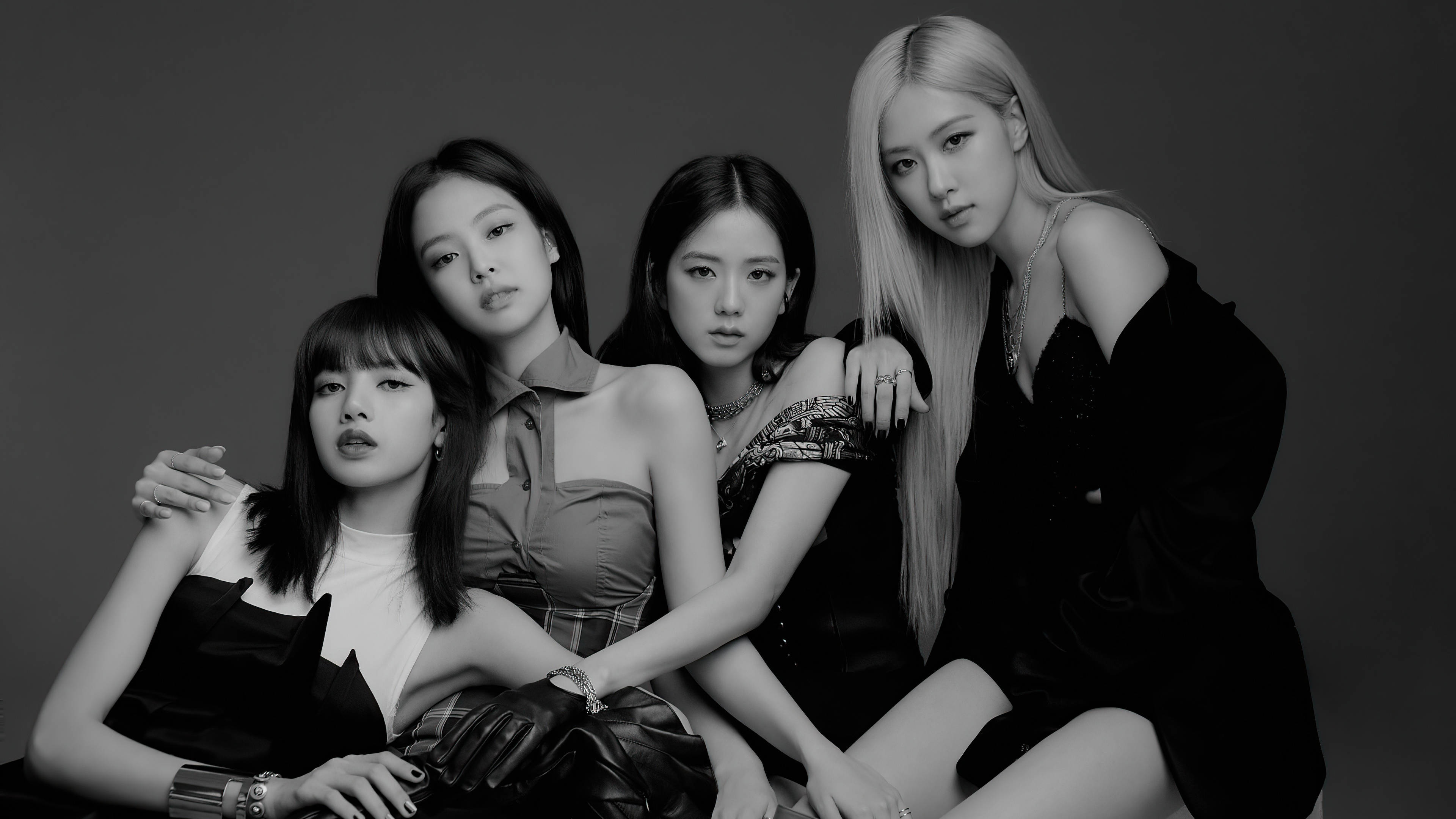 BLACKPINK 四人組合 Lisa Jennie Jisoo Rose 壁紙 — 四位時尚女性在單色工作室肖像中自信地擺姿勢，帶有戲劇性燈光和別緻服裝。