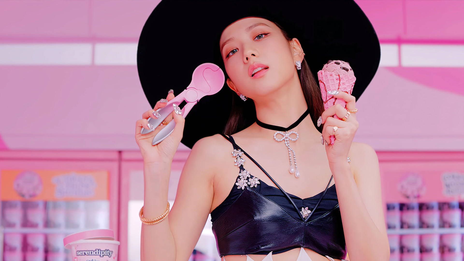 BLACKPINK 成員 Jisoo 持冰淇淋電腦桌面壁紙 壁紙 — 一位戴著黑色寬邊帽子的女士，在充滿活力的粉紅色背景前，手持粉紅色雪糕筒和勺子。