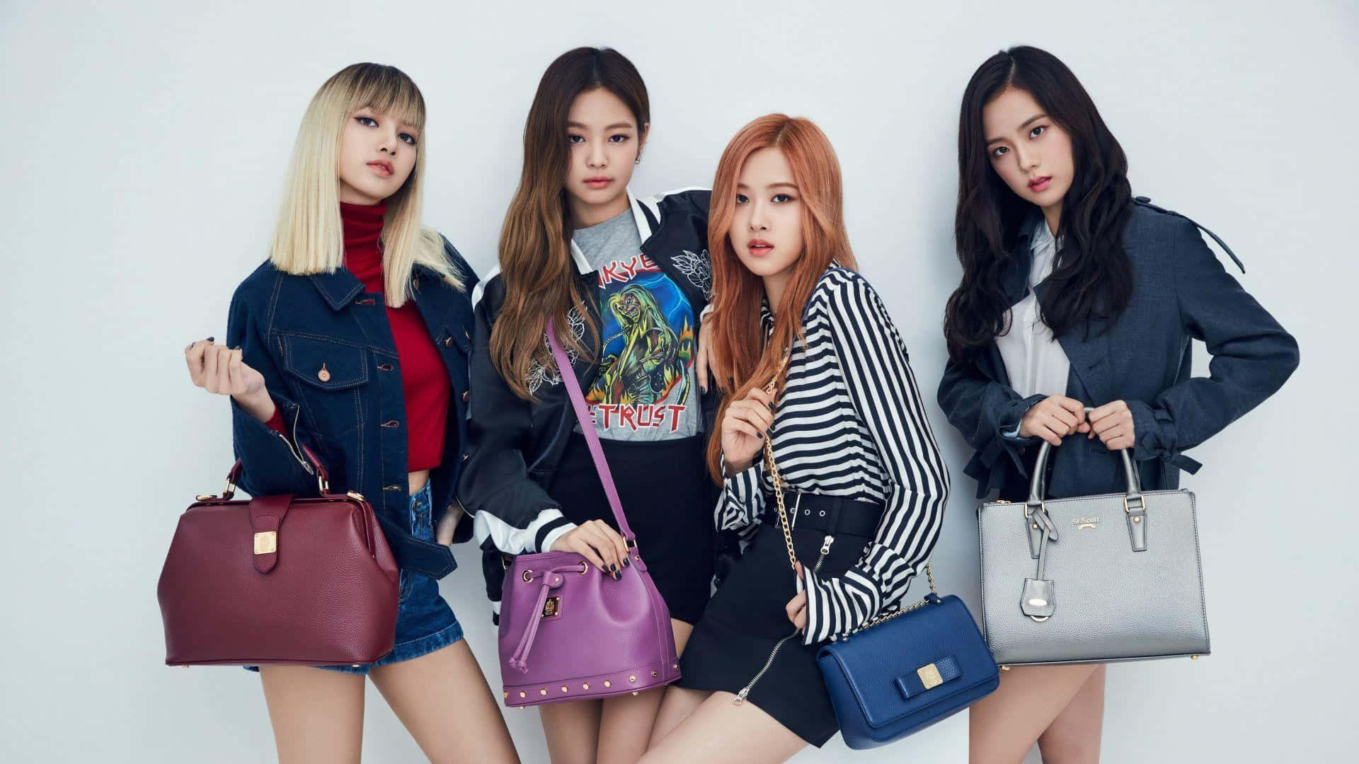 BLACKPINK 熱力點亮音樂界 壁紙 — 四位時尚女性自信地擺姿勢，背景為純白色，每人手持一個色彩繽紛的手袋。