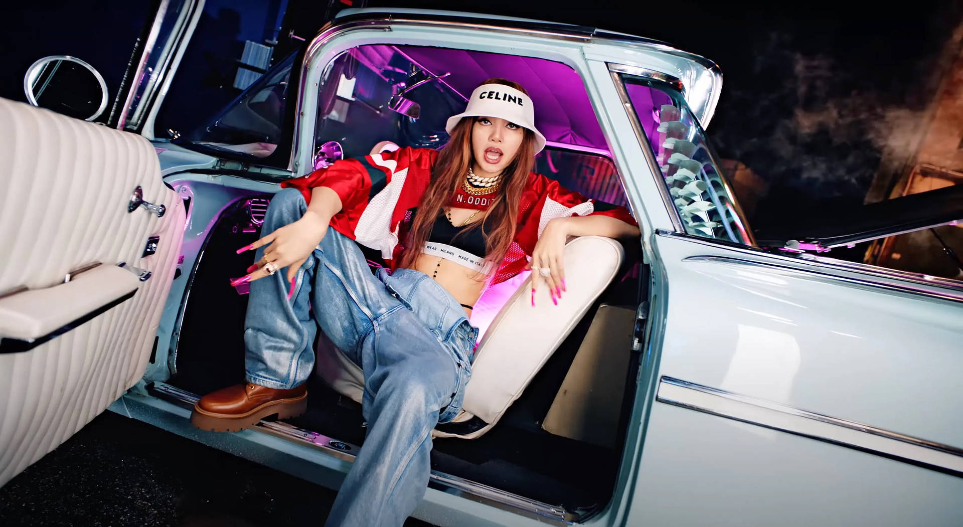 BLACKPINK成員Lisa的酷炫造型 壁紙 — 一位時尚女性在夜間霓虹燈下自信地坐在復古車的後座。