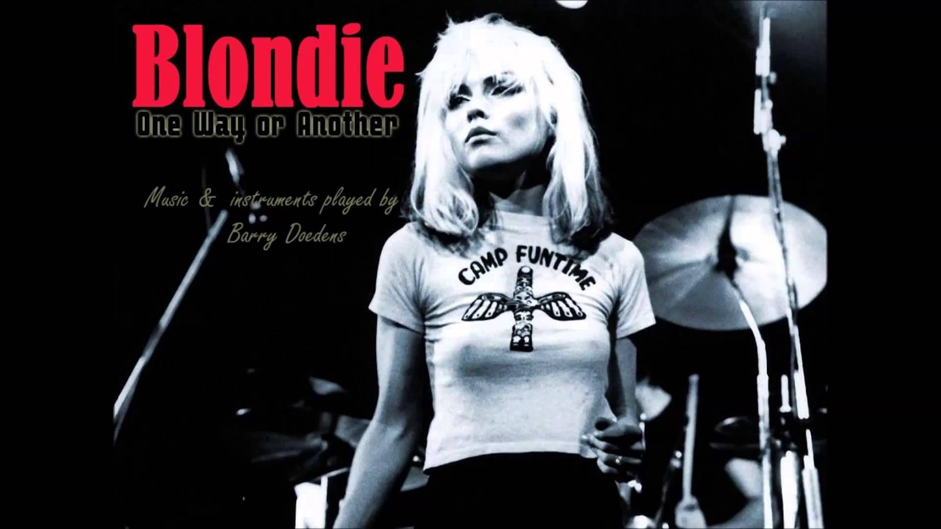 Blondie 在舞台上表演，身穿 Camp Funtime T恤，身後有鼓。