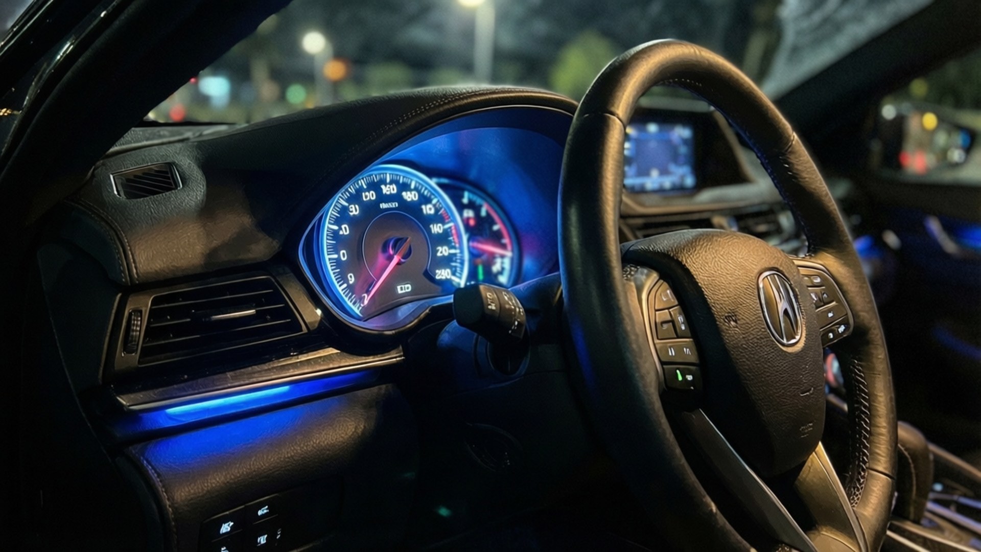 夜間以藍光點亮的汽車儀表板和方向盤