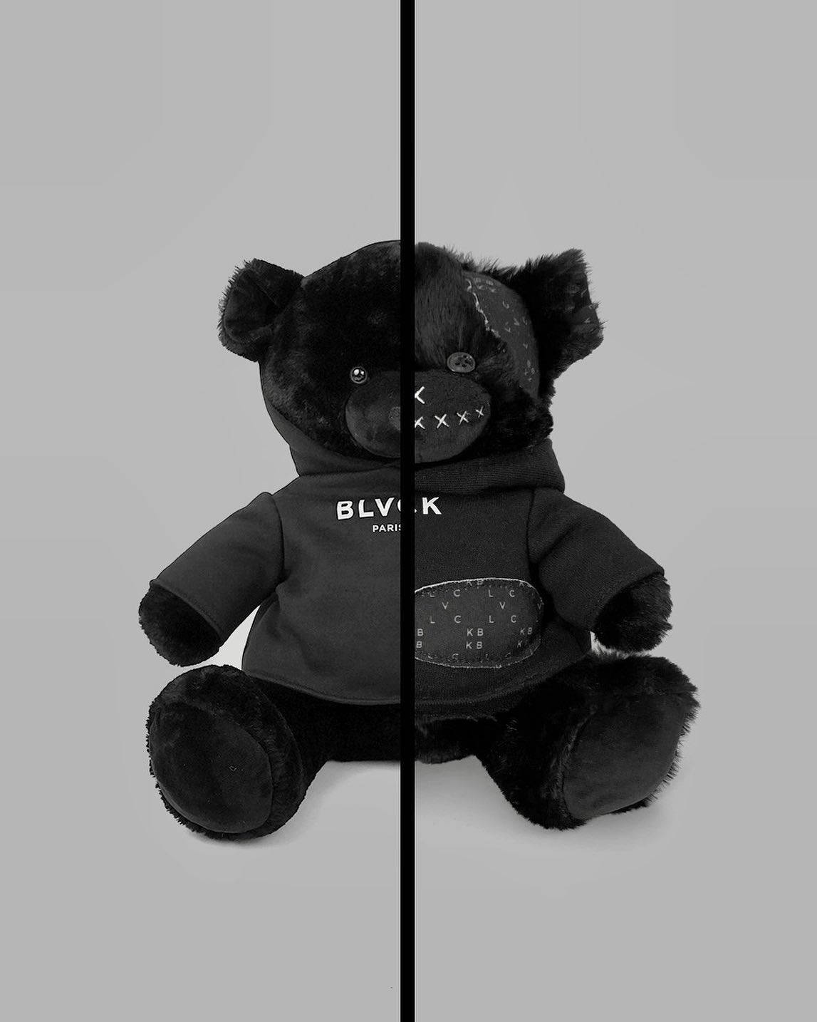 以Blvck巴黎打造經典時尚宣言 壁紙 — 一隻黑色泰迪熊從中間分開，一邊乾淨，另一邊縫有補丁，背景為灰色。