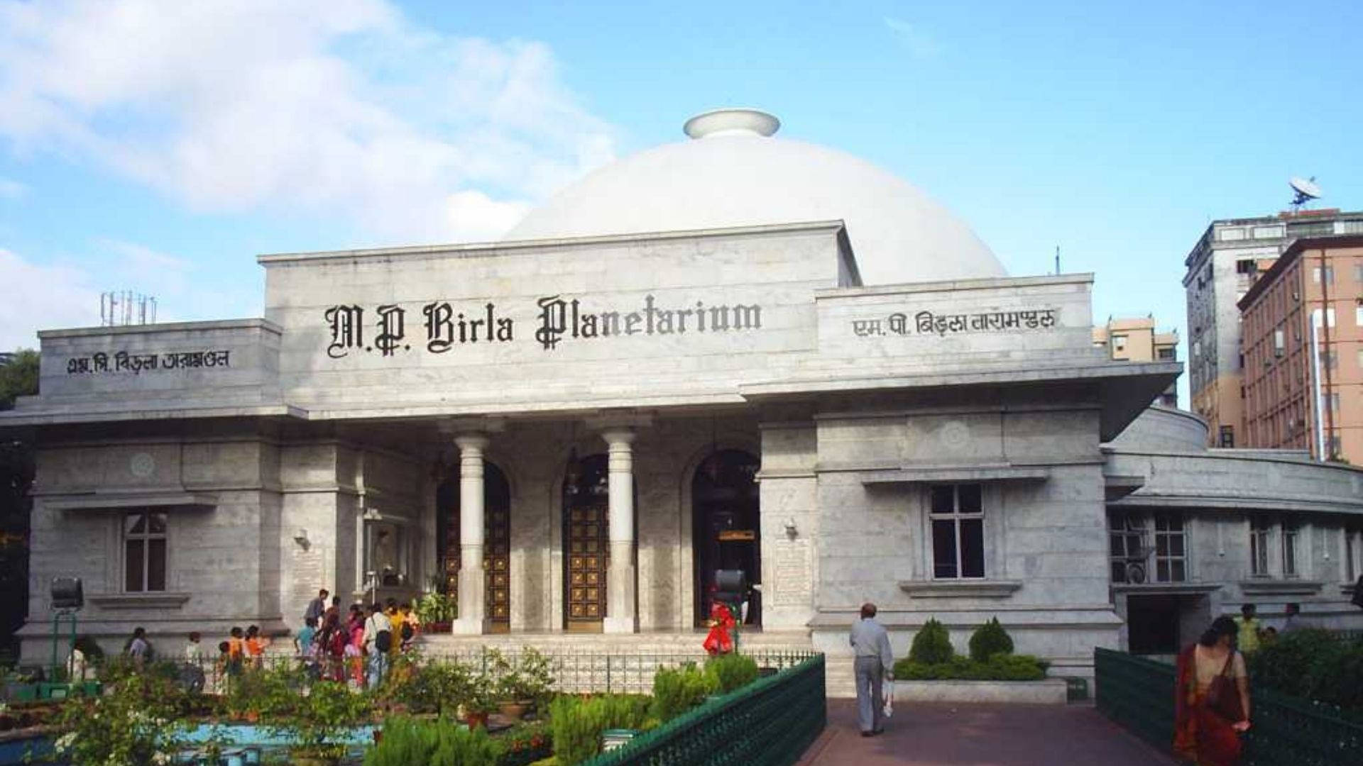 海得拉巴BM比爾拉天文館 壁紙 — 白色大理石建造的宏偉M.P. Birla天文館，圓頂和柱子在明亮的藍天下，有零星雲朵。