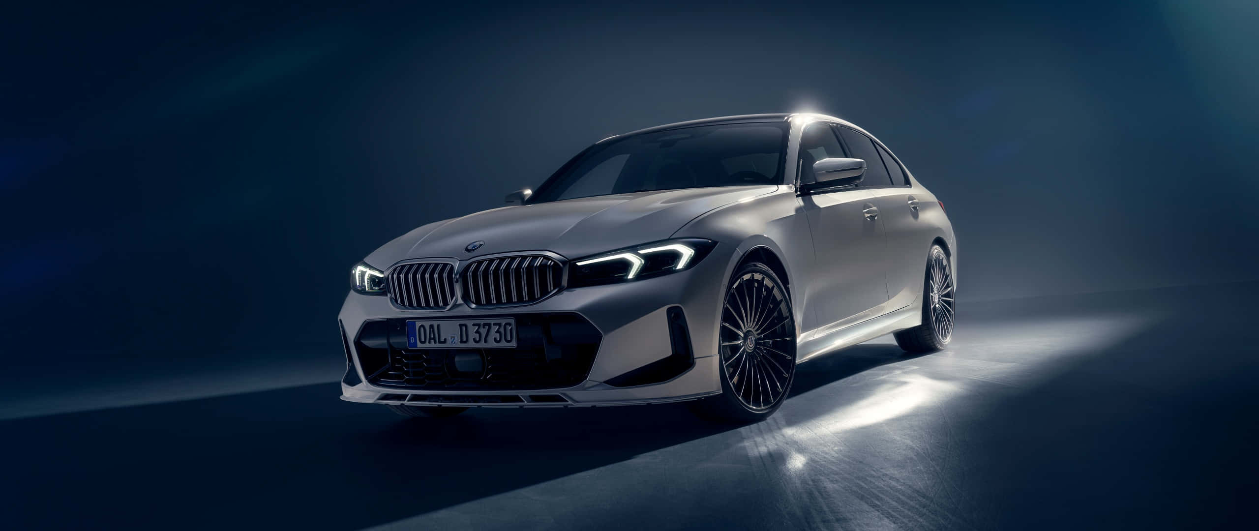 BMW 328 銀色豪華運動轎車 壁紙 — 一輛時尚的銀色寶馬轎車在黑暗的攝影棚背景下，在反射地板上閃耀著戲劇性的聚光燈。