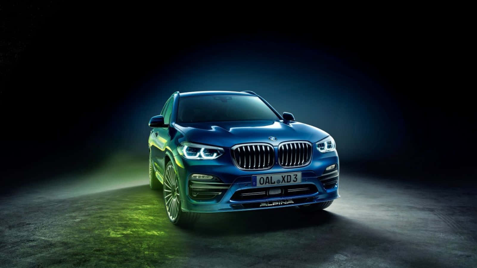 BMW Alpina XB7 SUV 金屬藍色攝影平板壁紙 壁紙 — 一輛時尚的藍色Alpina BMW SUV在戲劇性的攝影棚燈光下發光，綠色地板反射在黑暗背景上。