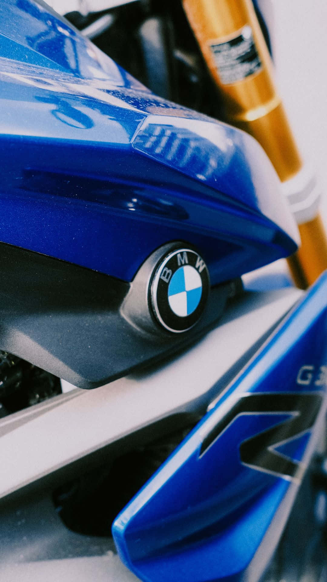 BMW Android 車輛影像 壁紙 — 特寫一輛光澤藍色BMW電單車，配金色前叉和銳利線條，在明亮光線下。