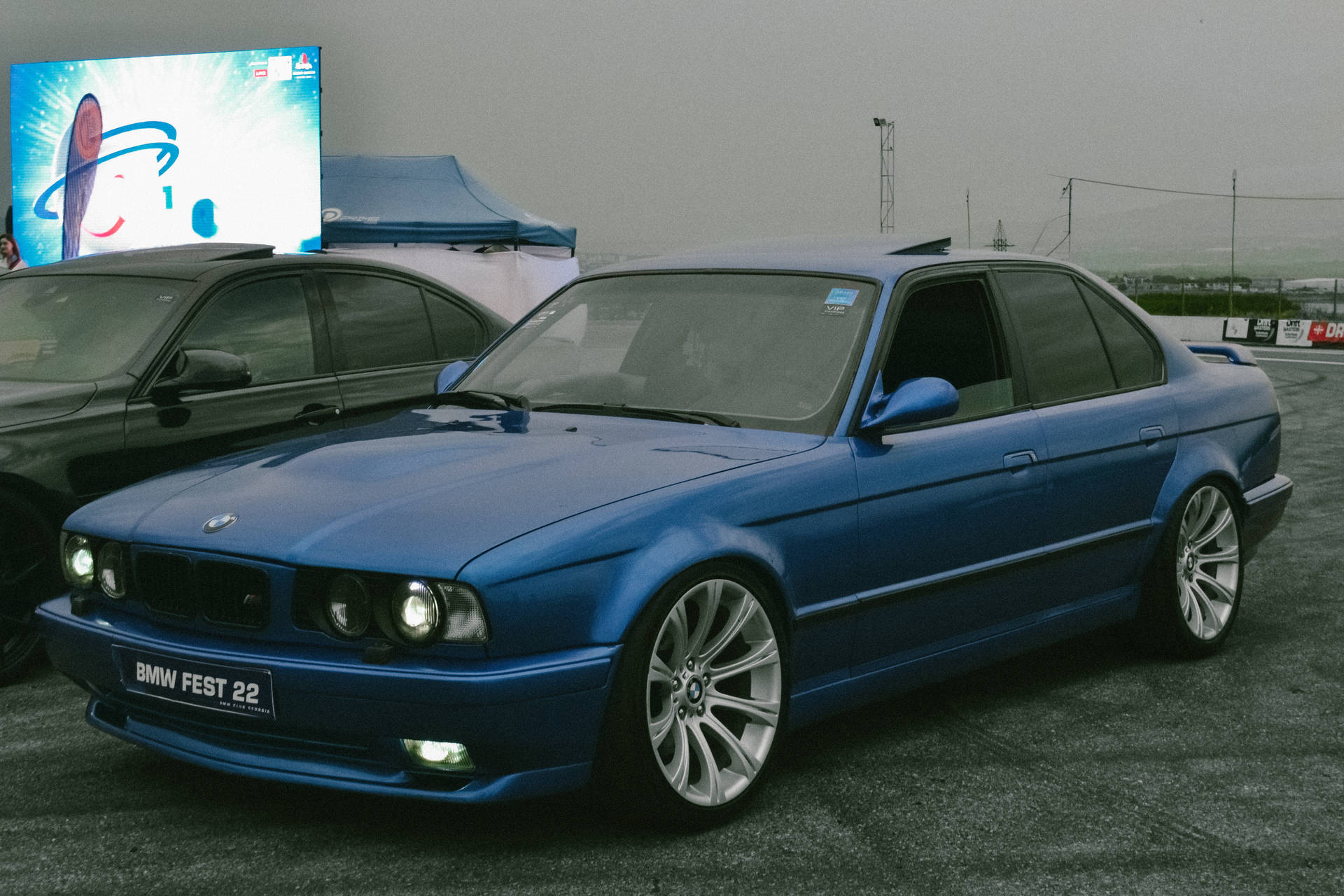 BMW Fest 22車展上灰色路面上的藍色BMW E36轎車。