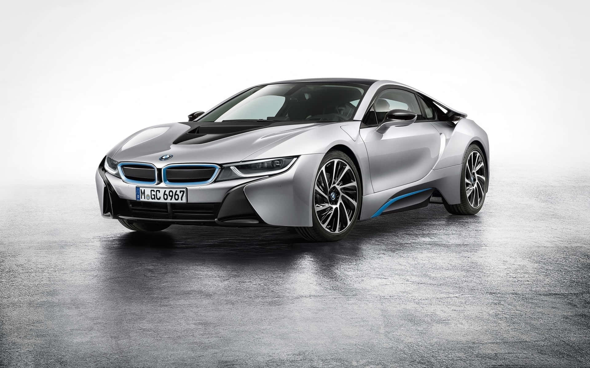 銀色BMW i8電動跑車，藍色飾邊，停在濕混凝土車道上。