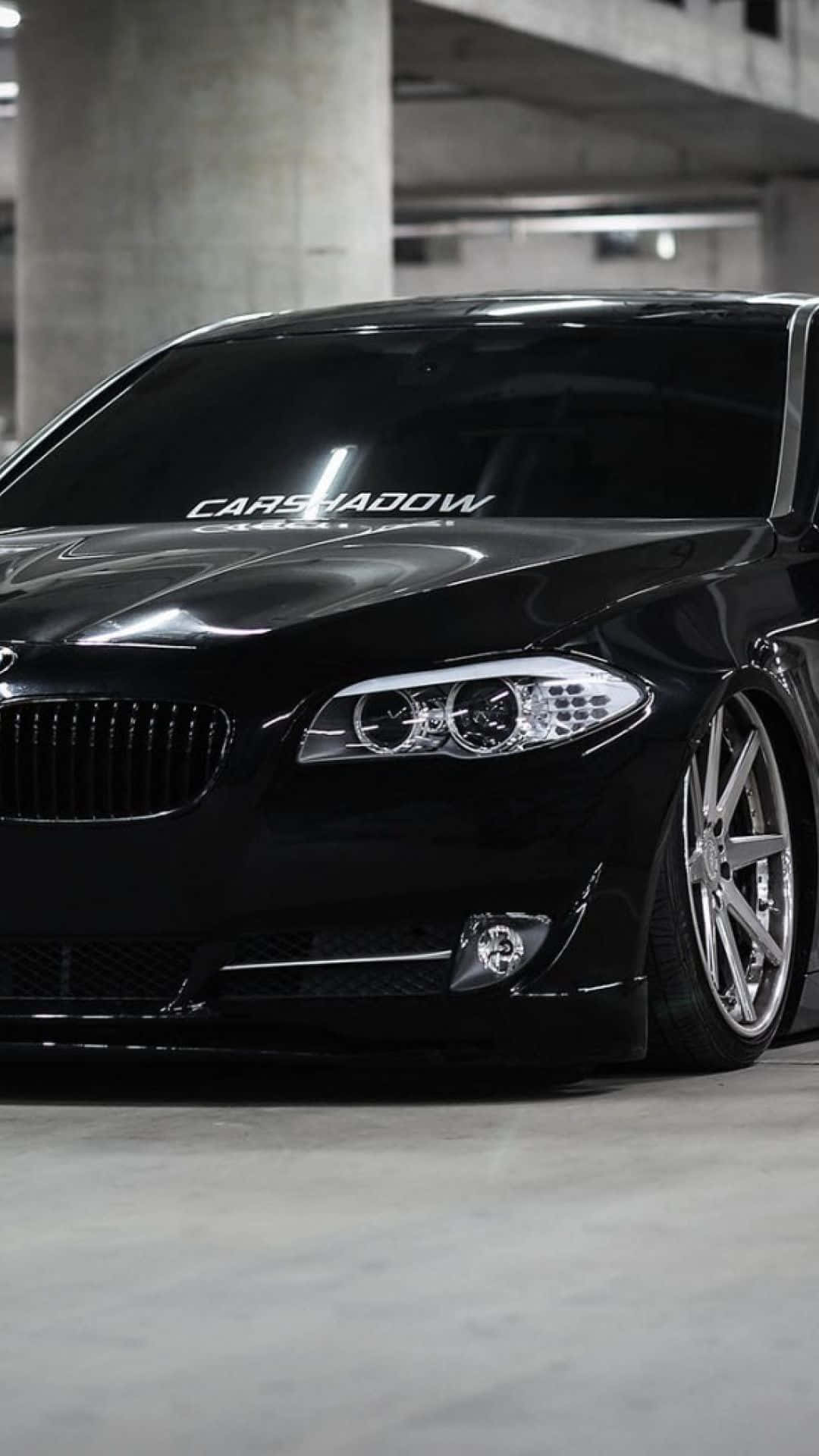黑色BMW房車配自訂輪圈在混凝土車庫。