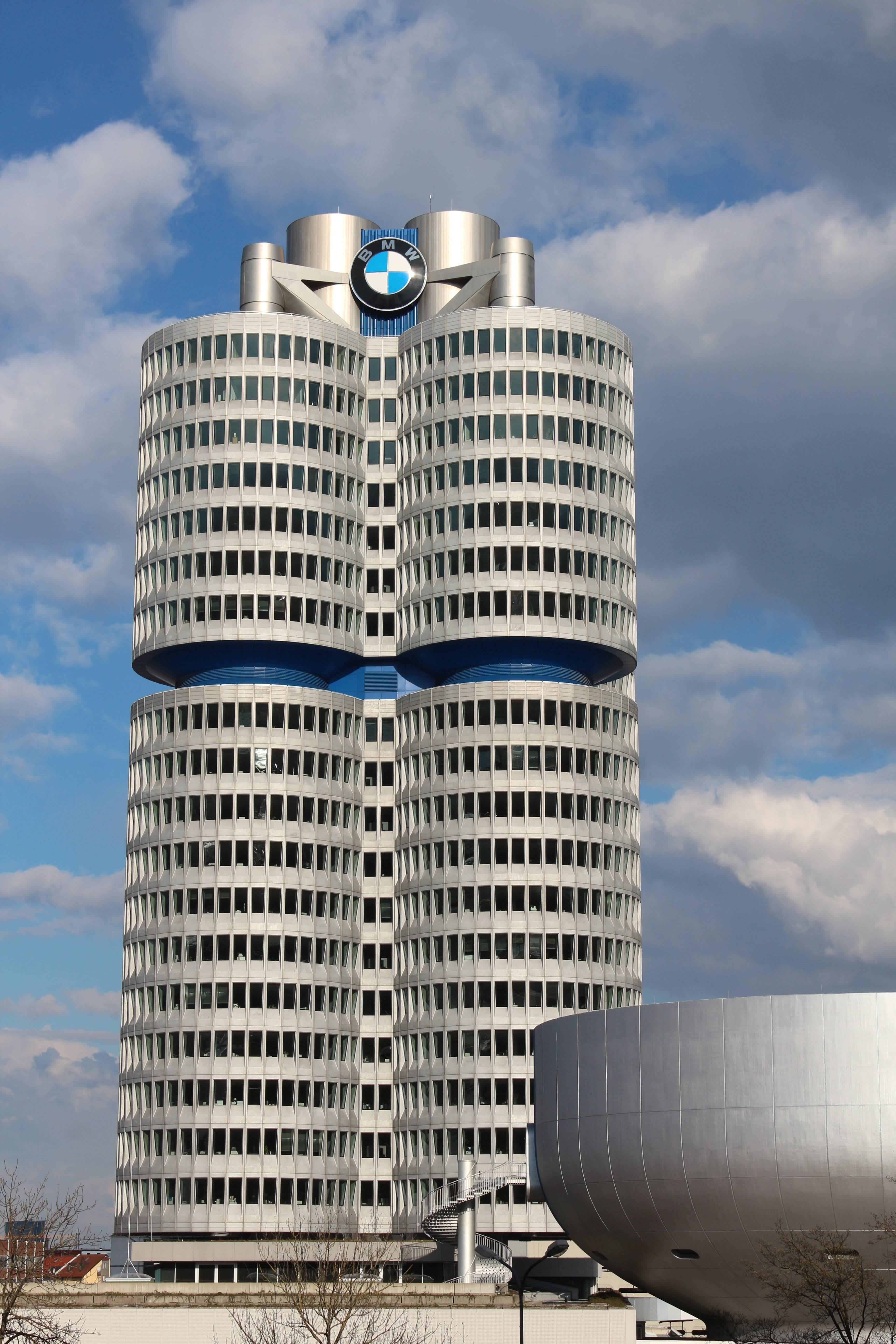 慕尼黑BMW總部 壁紙 — 標誌性的BMW總部大樓在戲劇性的藍天和蓬鬆的白雲襯托下聳立。