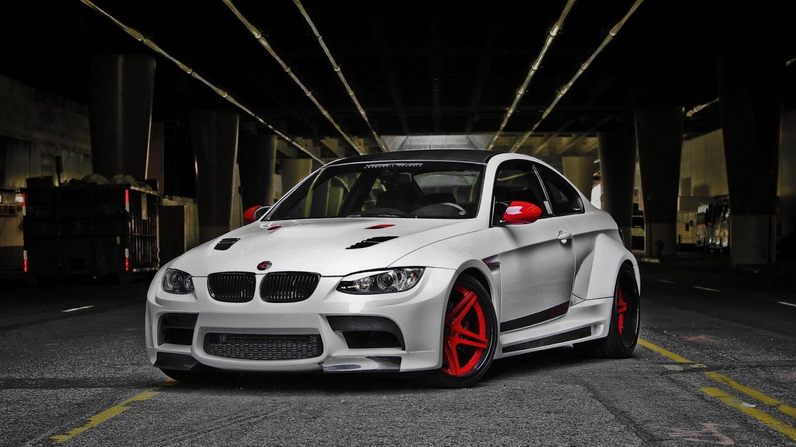紅白配色BMW M系列跑車 壁紙 — 一輛白色BMW M3，帶有紅色飾件和定制輪圈，夜間停放在光線昏暗的混凝土天橋下。