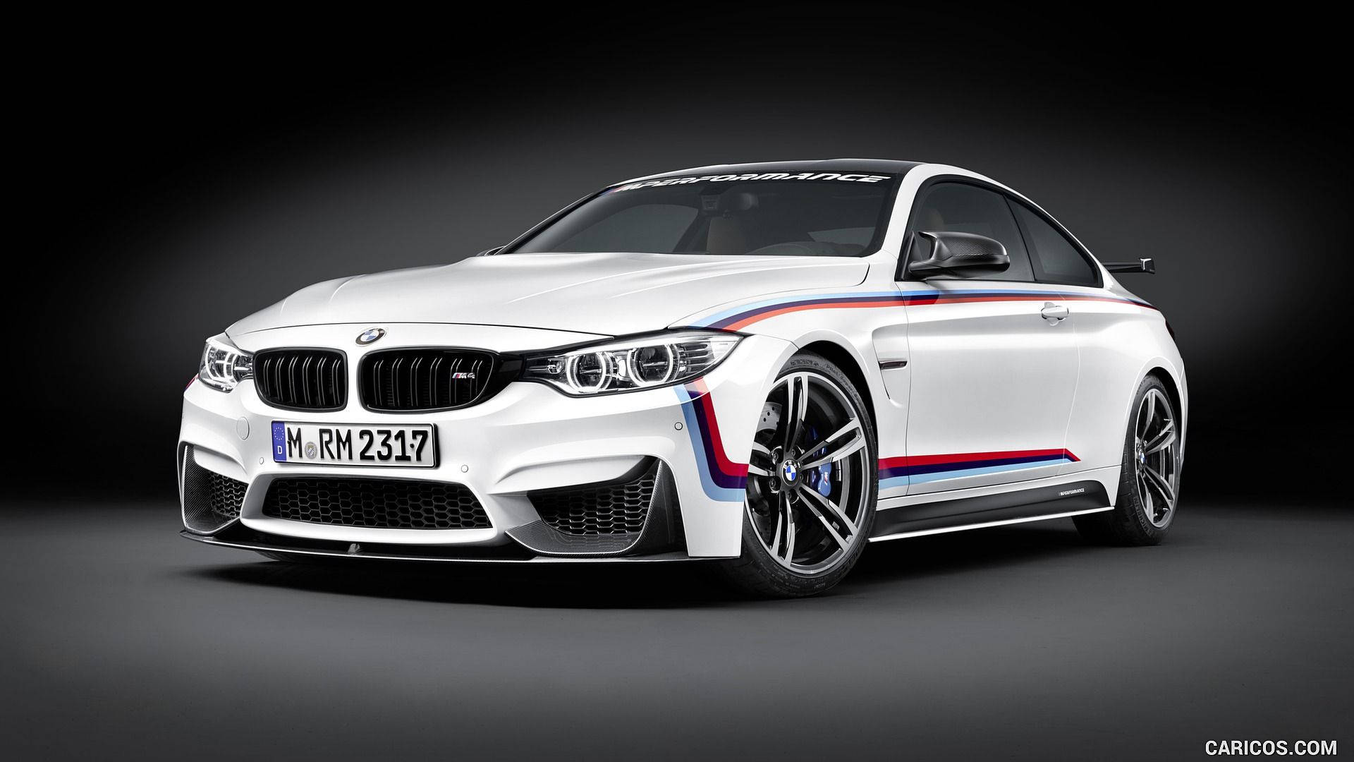 BMW M 系列車款細節 壁紙 — 一部時尚的白色BMW M4 GTS，帶有標誌性的藍、紅、白賽車條紋，在深色工作室背景下傲然挺立。