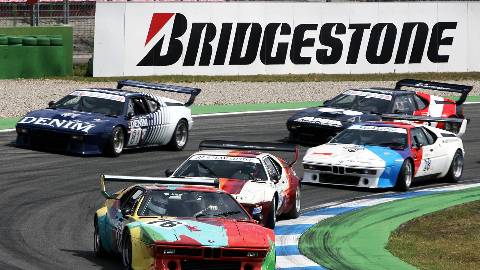 復古賽車在帶有Bridgestone品牌的賽道上飛馳。