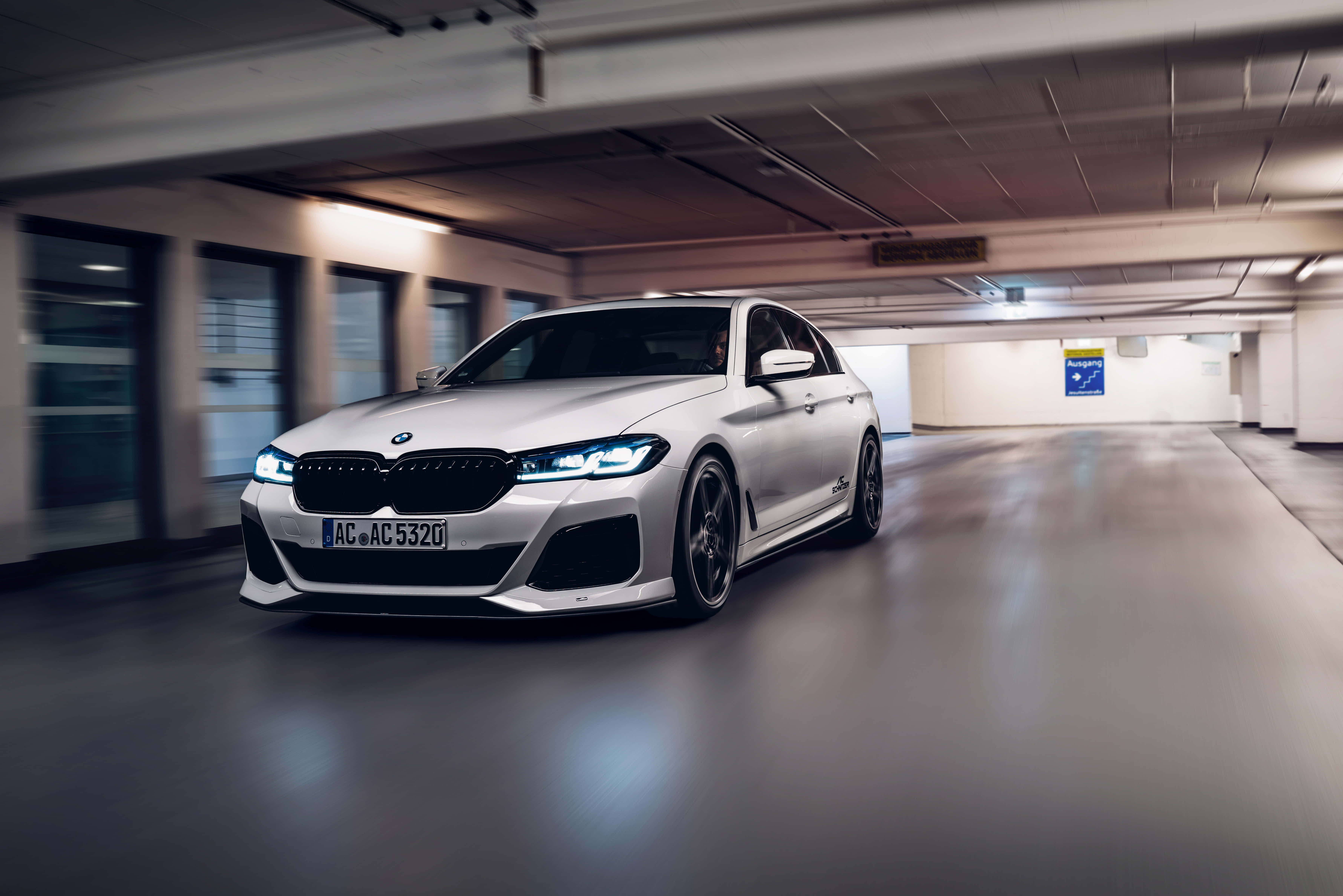 經典BMW M5，尊貴4K畫質 壁紙 — 一輛時尚的銀色寶馬M5在地下停車場高速行駛，周圍環境呈現動態模糊效果。