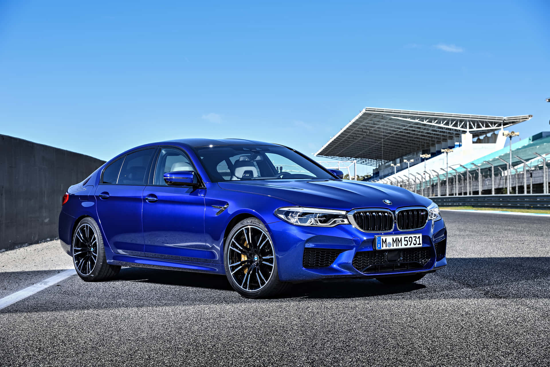 藍色BMW M5房車停放在有看台的賽道上。