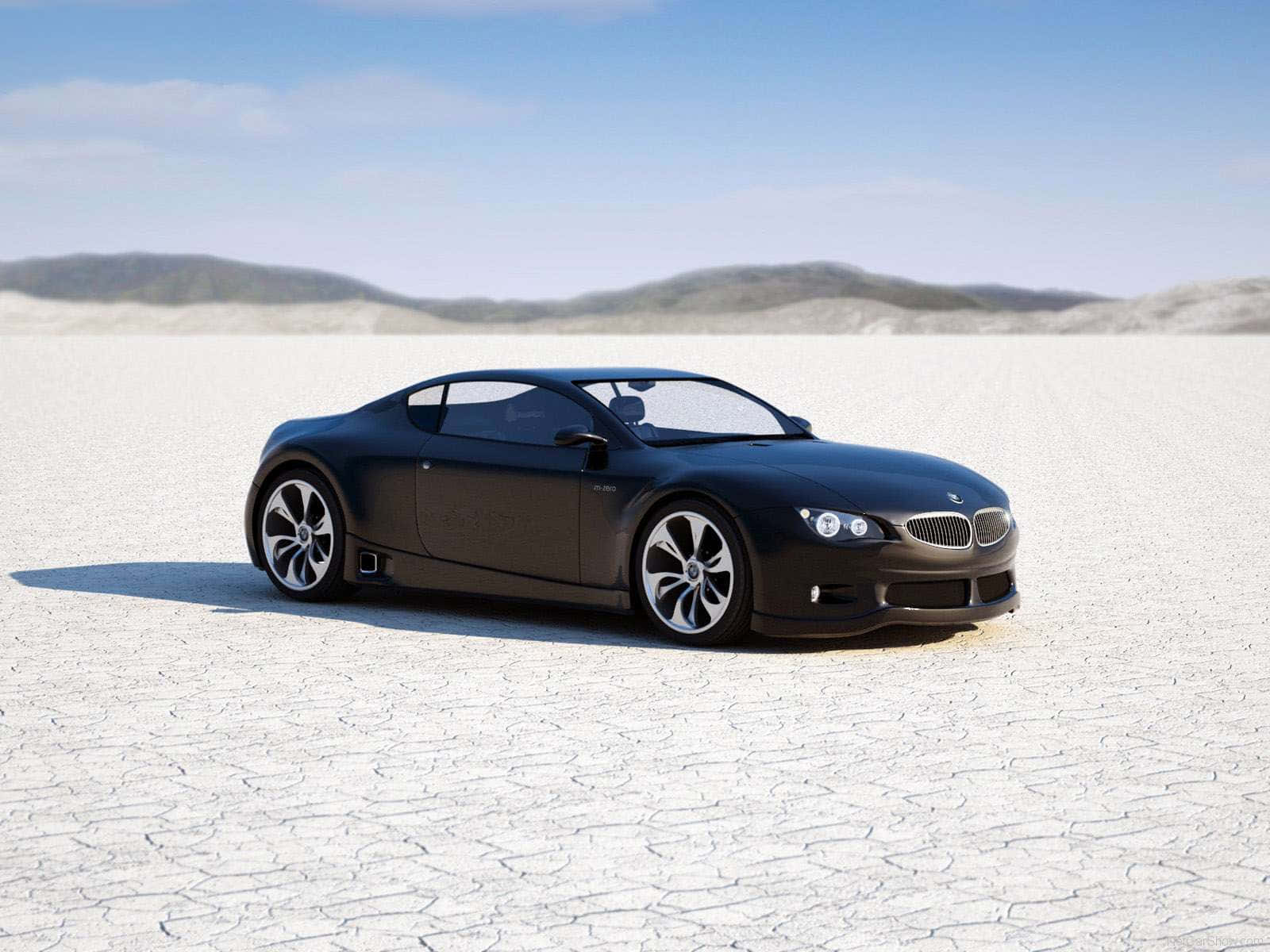 日落時分，龜裂的沙漠地面上的黑色BMW跑車。