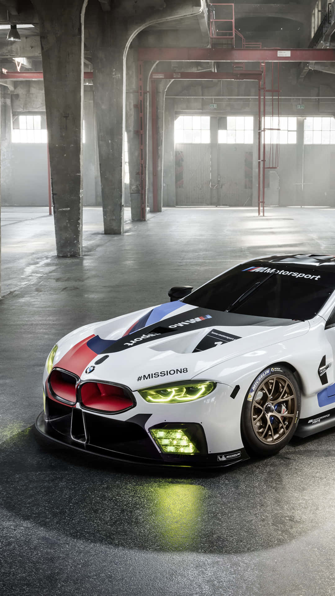 白色BMW賽車在工業倉庫中發光的頭燈。