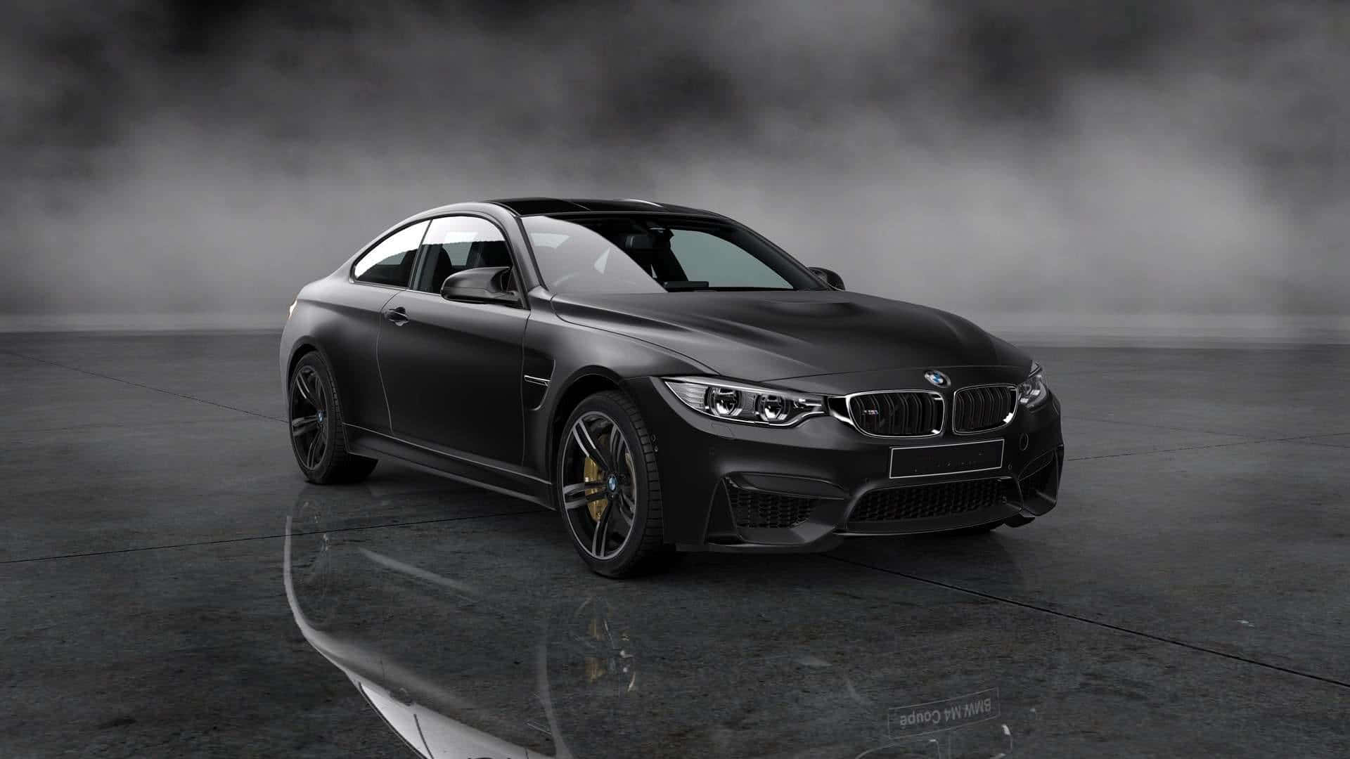 陽光街道上的時尚現代BMW轎車 壁紙 — 一輛啞光黑色BMW M4雙門轎跑車在攝影棚燈光下閃耀，金色制動卡鉗在煙灰色背景襯托下清晰可見。