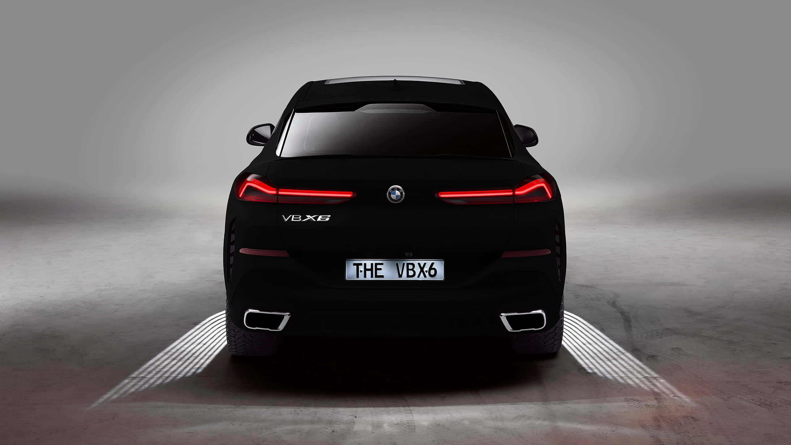 BMW X6概念車 - BMW X6概念車 壁紙 — 從後方觀看的時尚黑色BMW V8X6跑車，帶有發光的紅色尾燈和照明地面圖案，在簡約的攝影棚環境中。