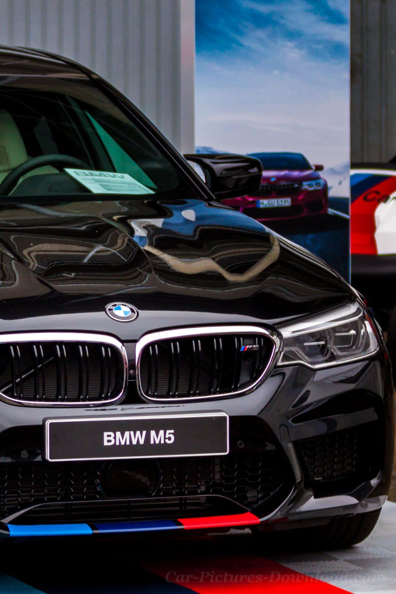 黑色BMW M5跑車帶有M Performance條紋，室內展示。