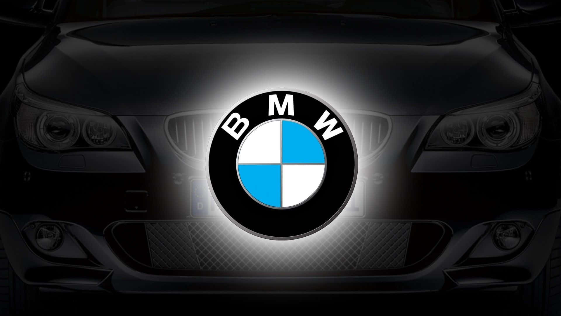 深色引擎蓋上發光的BMW標誌，車頭燈可見。