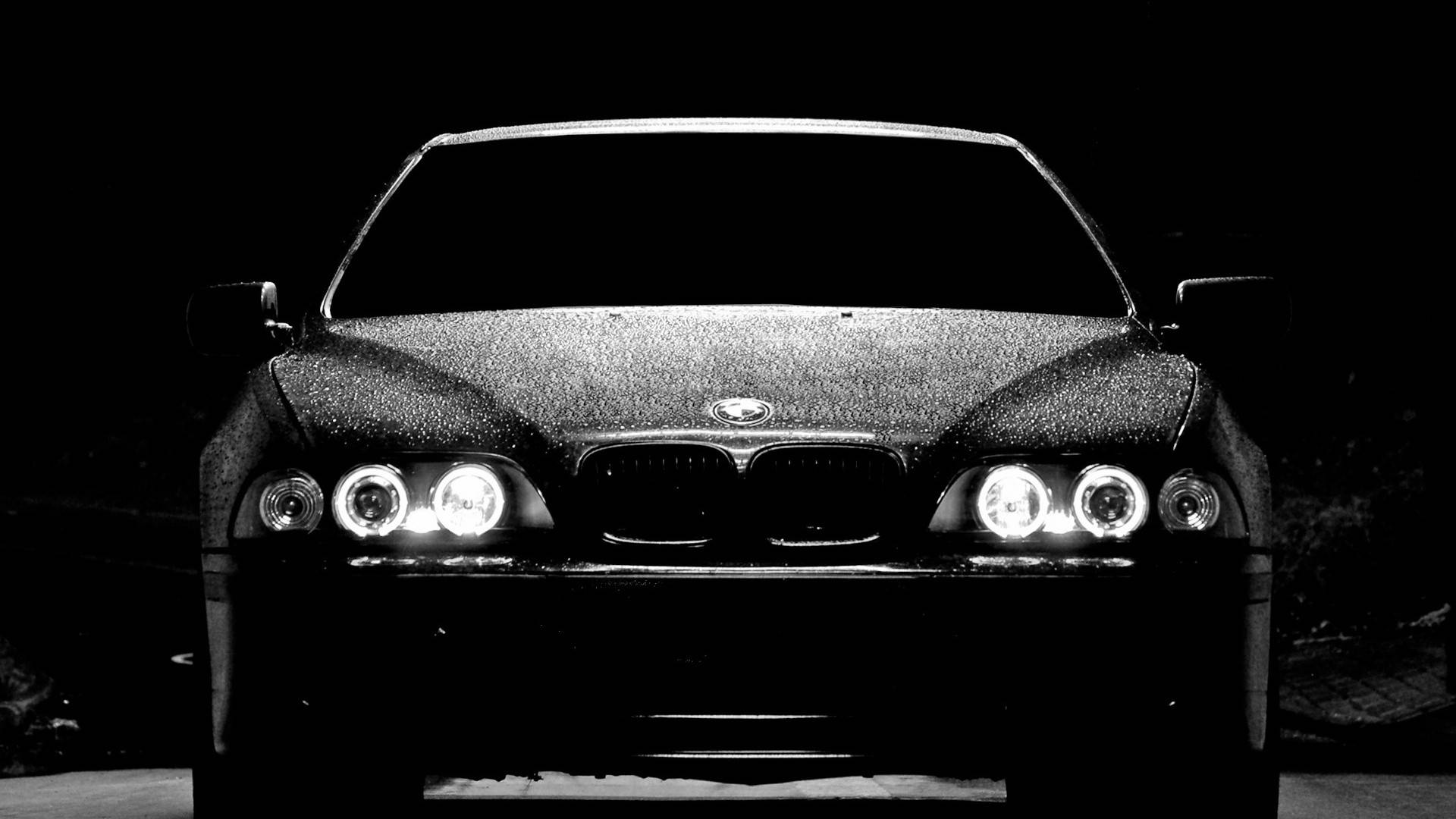 Wet 桌布 壁紙 — BMW 汽車前格柵和頭燈在黑暗背景下發光的黑白特寫。