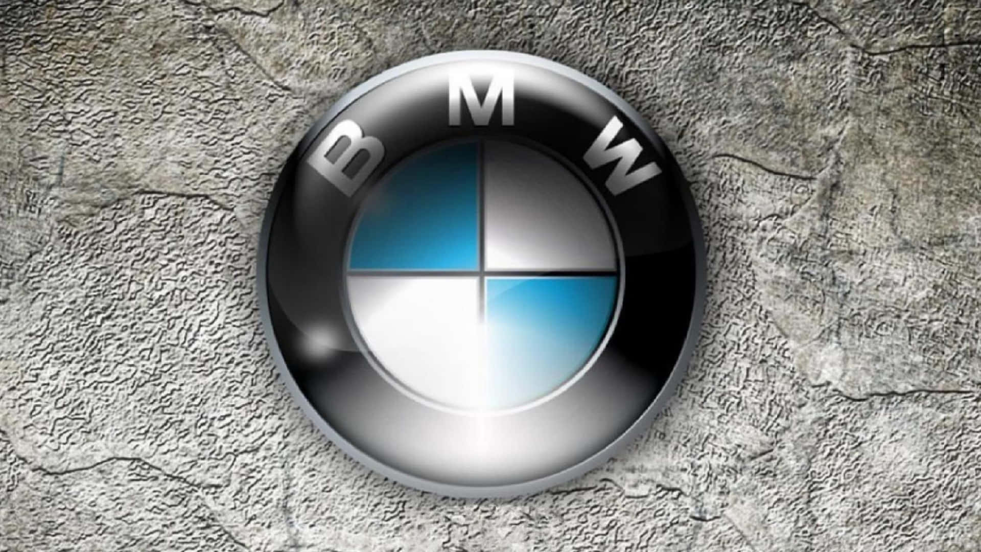 BMW標誌 壁紙 — 一個帶有藍色和白色象限的光面BMW標誌位於粗糙的灰色混凝土牆中央。