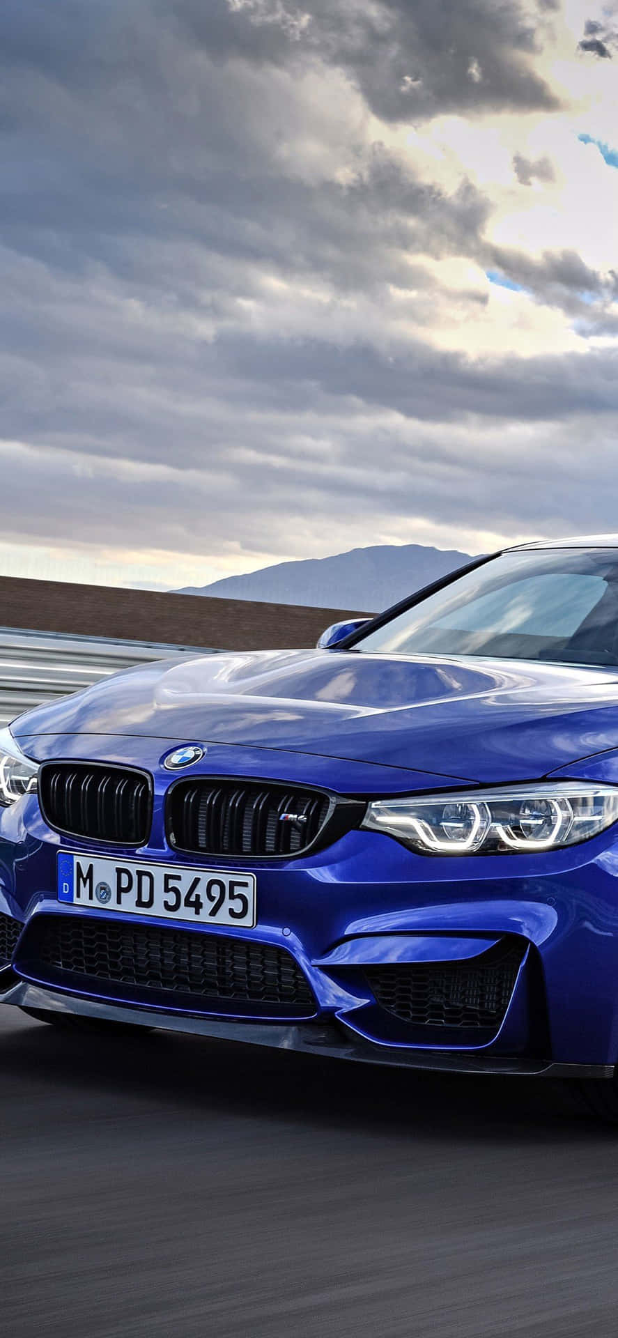 日落時分藍色BMW M4在山路上飛馳。
