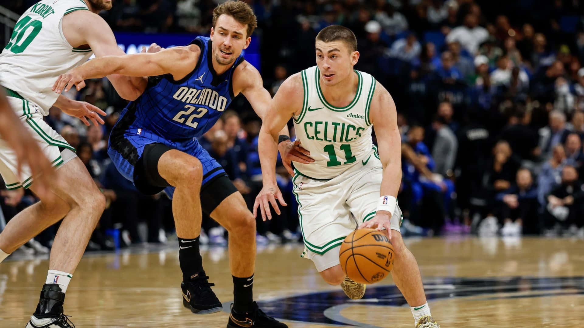  壁紙 — 波士頓塞爾特人球員在激烈的NBA比賽中運球，同時被奧蘭多魔術的兩名防守球員緊密防守。