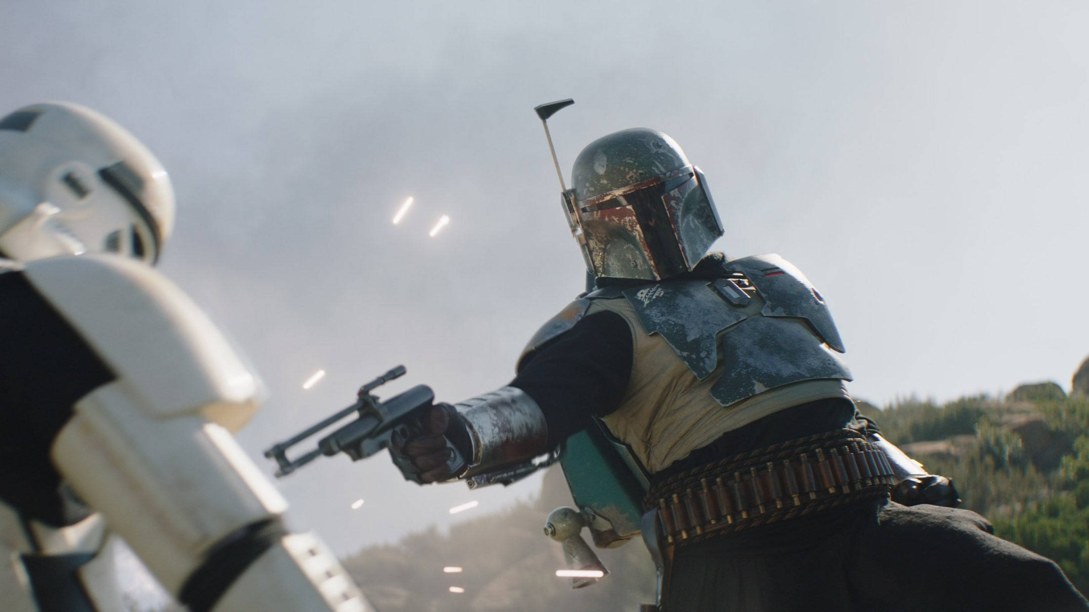 赏金猎人 Boba Fett 与帝国冲锋队员激战 壁紙 — 波巴·費特穿著破舊的盔甲，在塵土飛揚的戶外戰鬥中，向一名風暴兵發射爆能槍，周圍有飛濺的子彈火花。