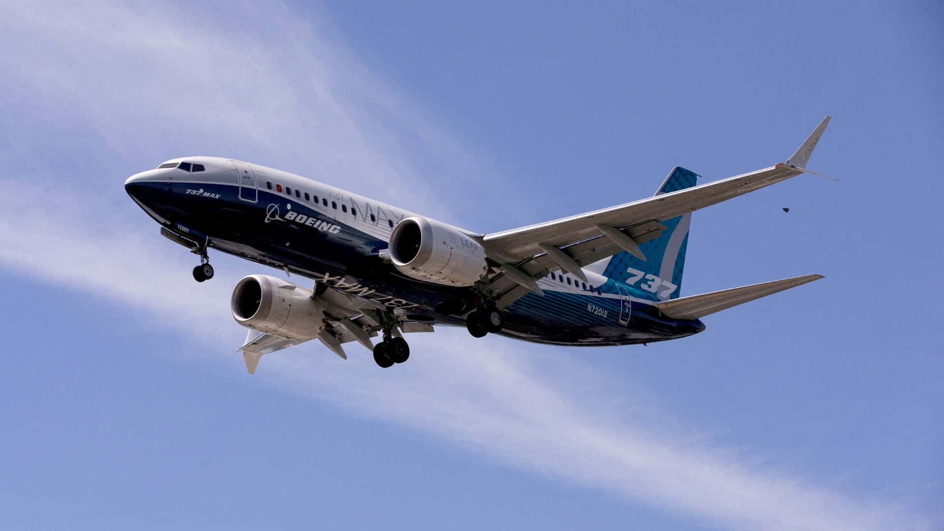  壁紙 — 一架藍白塗裝的波音737飛機正爬升向晴朗藍天，天空中有縷縷薄雲。