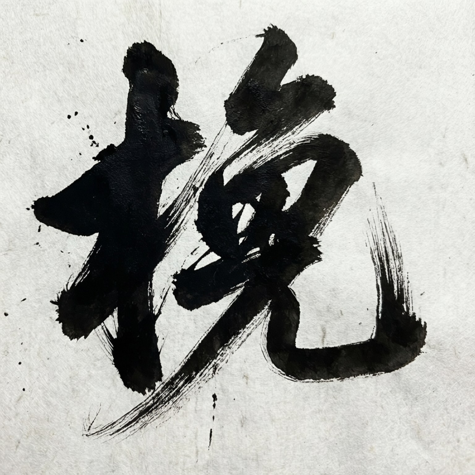 在帶有紋理的紙張上以粗獷黑色筆觸書寫的日本漢字。