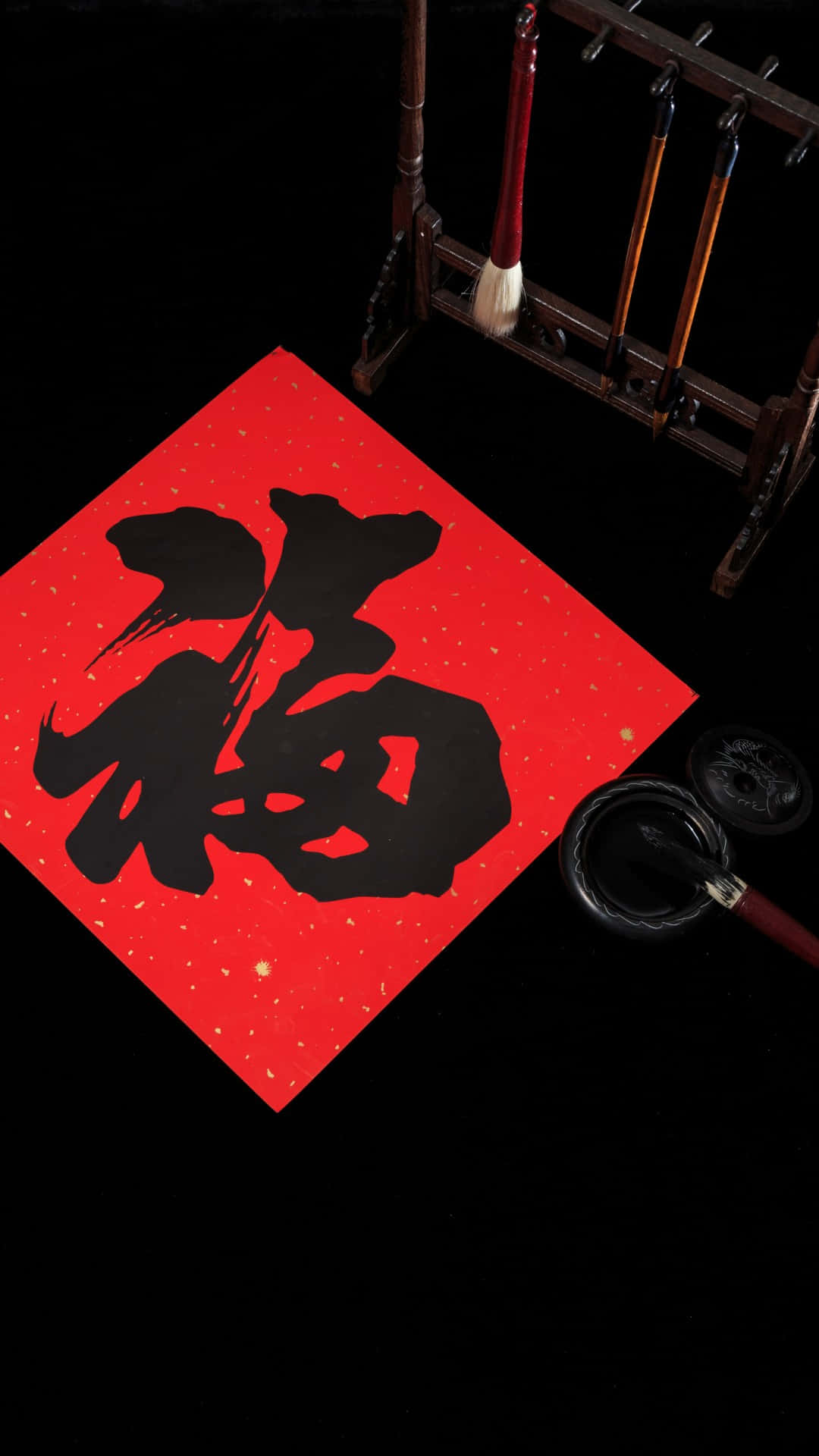  壁紙 — 在深色背景上，質感紅紙上有一個大膽的黑色書法字「福」，配以傳統毛筆和硯台。