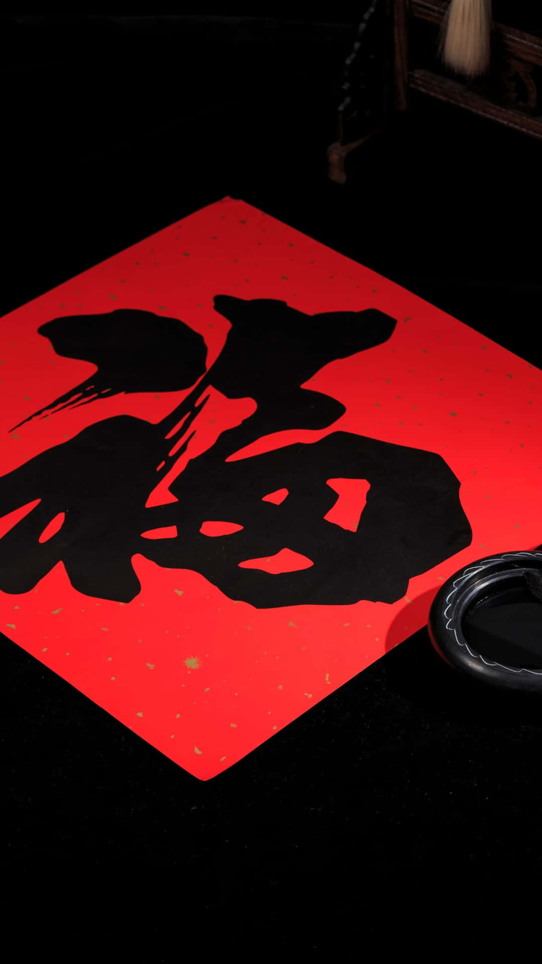  壁紙 — 一個粗體黑色漢字「福」寫在鮮紅色紙上，旁邊有毛筆和硯台，背景為深色。